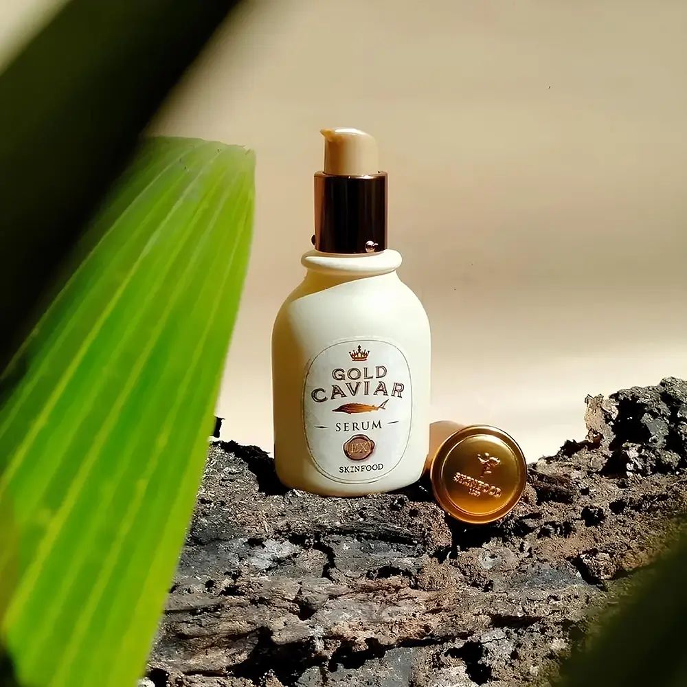 Flacone di siero Gold Caviar con tappo dorato. Testo: Gold Caviar Serum, SKINFOOD.