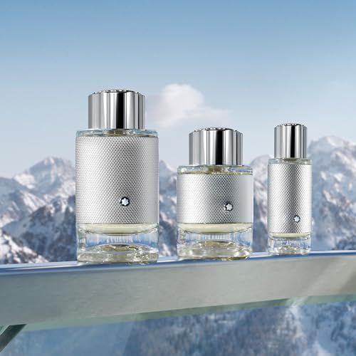 Tre flaconi di profumo con tappi argentati davanti a un panorama montano. Logo Montblanc.