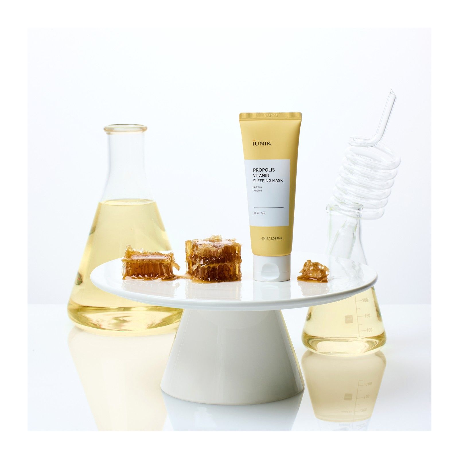 Tubo di maschera da notte Propolis Vitamina iUNIK con favi e fiale da laboratorio.