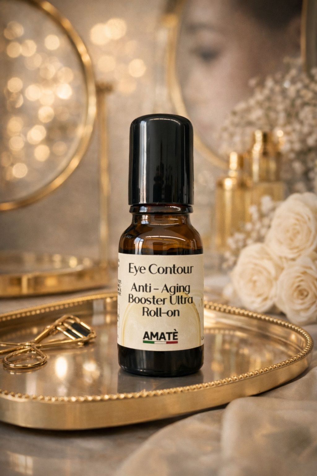Flacone in vetro marrone con tappo nero. Scritta: Eye Contour Anti-Aging Booster Ultra Roll-on. Marchio: Amatè. Su vassoio dorato.
