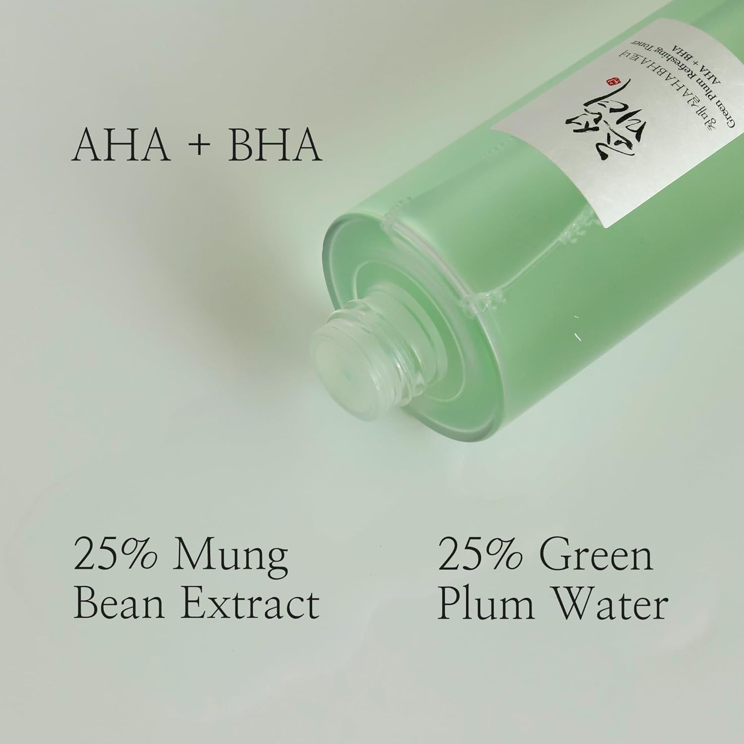 Flacone di toner, in diagonale dal basso. Scritta: AHA + BHA. Testo: 25% Estratto di fagioli mungo, 25% Acqua di prugna verde.