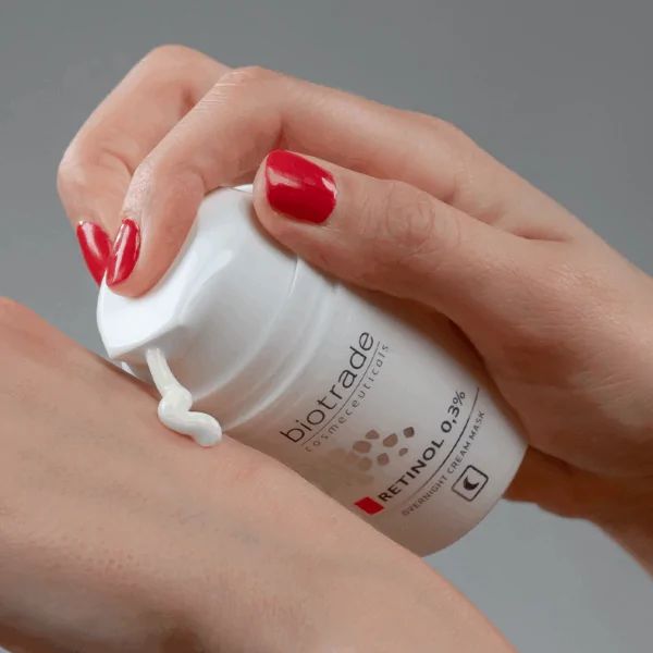 Flacone bianco Biotrade, Retinolo 0,3% e maschera notte. Crema applicata sulla pelle.