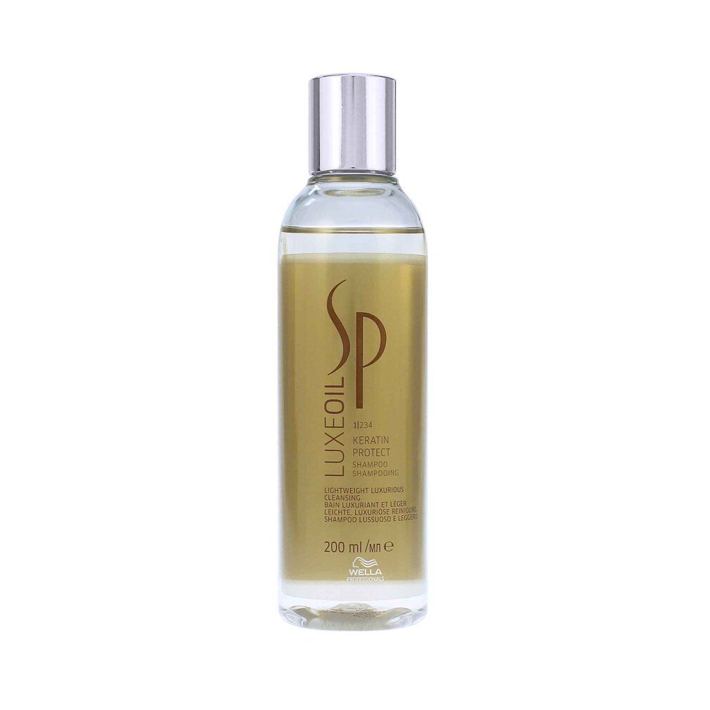 Shampoo Wella SP Luxe Oil. Bottiglia trasparente con liquido dorato. Tappo argentato. Etichetta con testo.