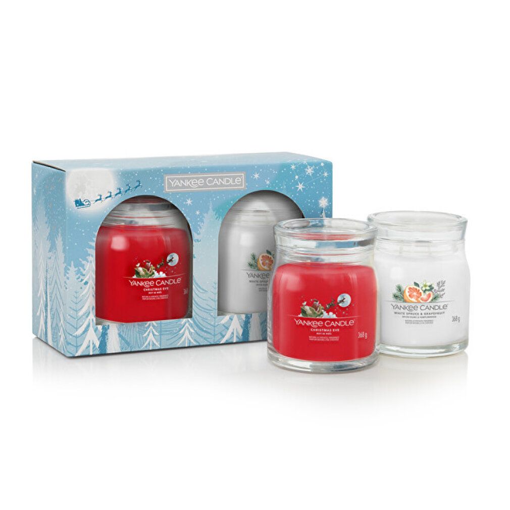 Confezione regalo con due candele in vasi di vetro. Candela rossa e crema in confezione natalizia. Marchio Yankee Candle.