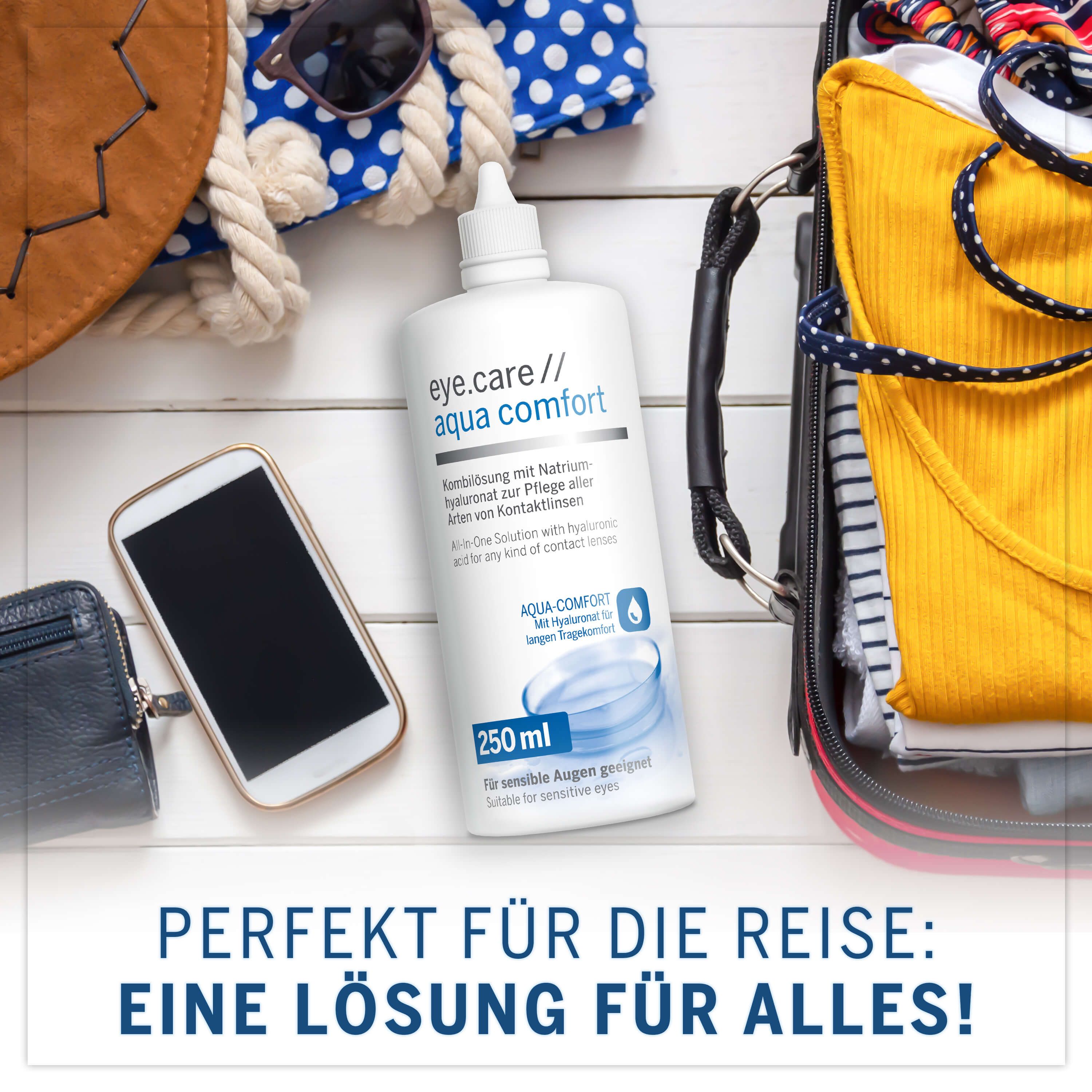 Flacone eye.care aqua comfort, 250 ml, accanto a smartphone, portafoglio, valigia. Testo: Perfetto per il viaggio: una soluzione per tutto!
