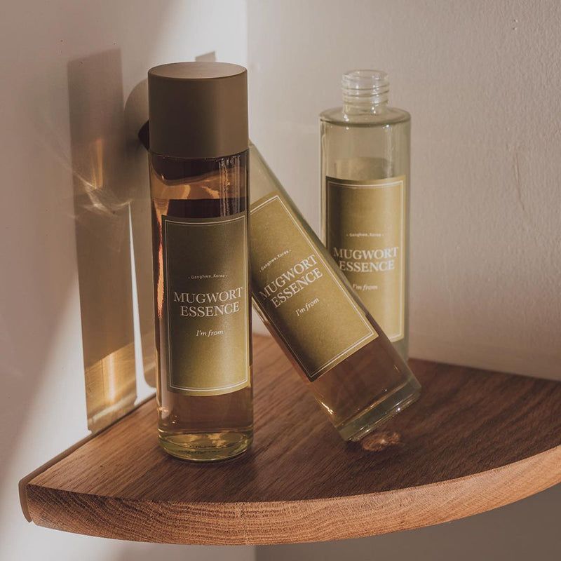 Tre flaconi su una mensola di legno. Etichette con nomi di prodotti.