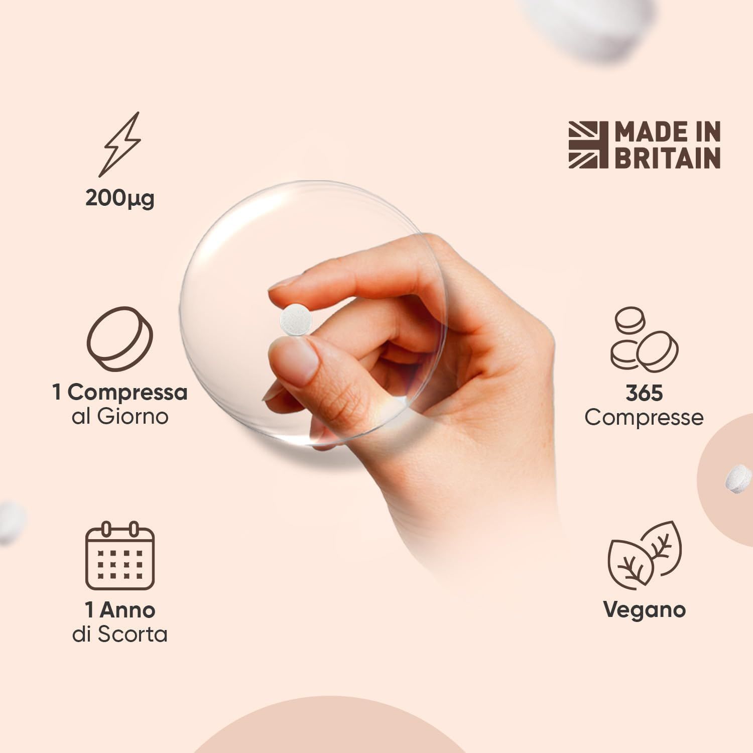 Mano che tiene una compressa. Testo: 200µg, 1 compressa al giorno, 365 compresse, 1 anno di scorta, vegano, Made in Britain.