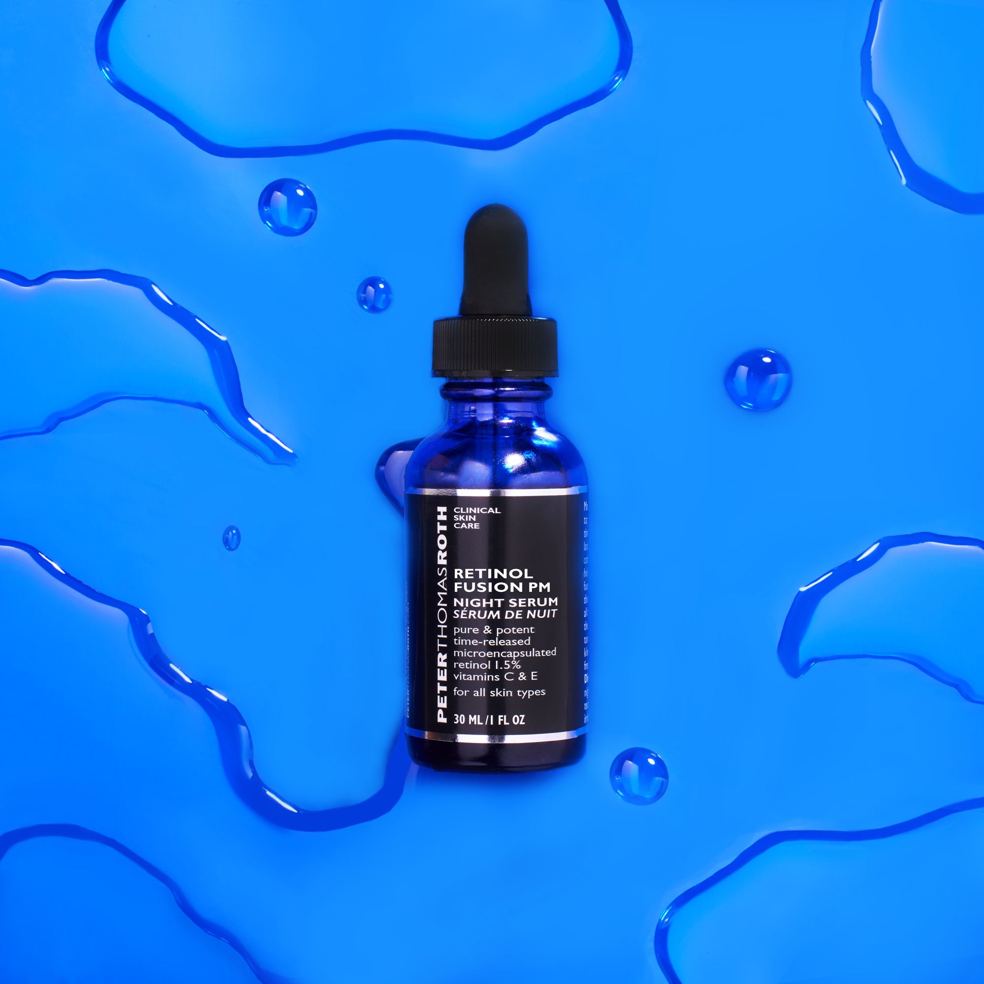 Flacone di vetro blu con tappo nero e pipetta su sfondo blu con gocce d'acqua. Etichetta visibile.