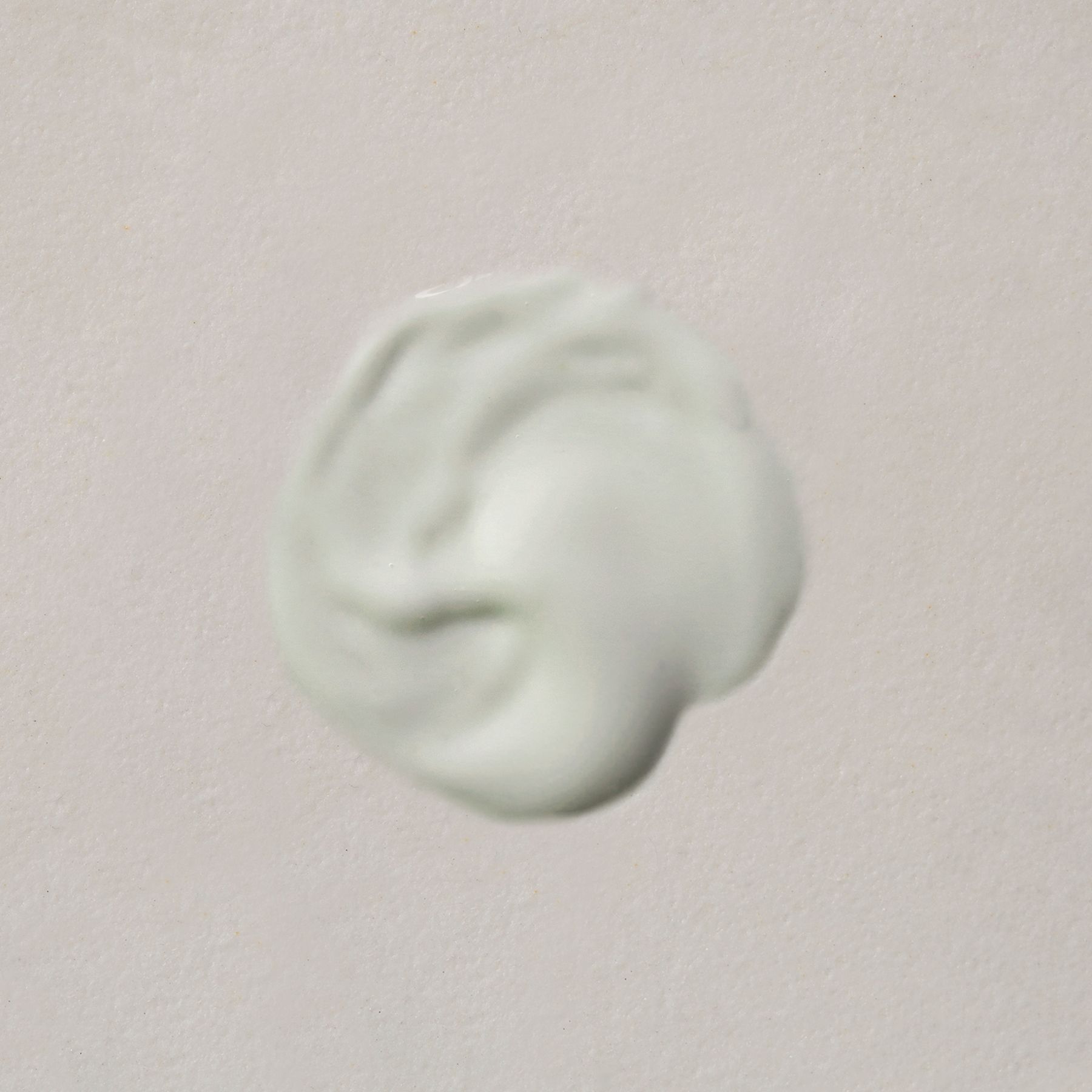 Una macchia di maschera viso verde chiaro su sfondo chiaro.