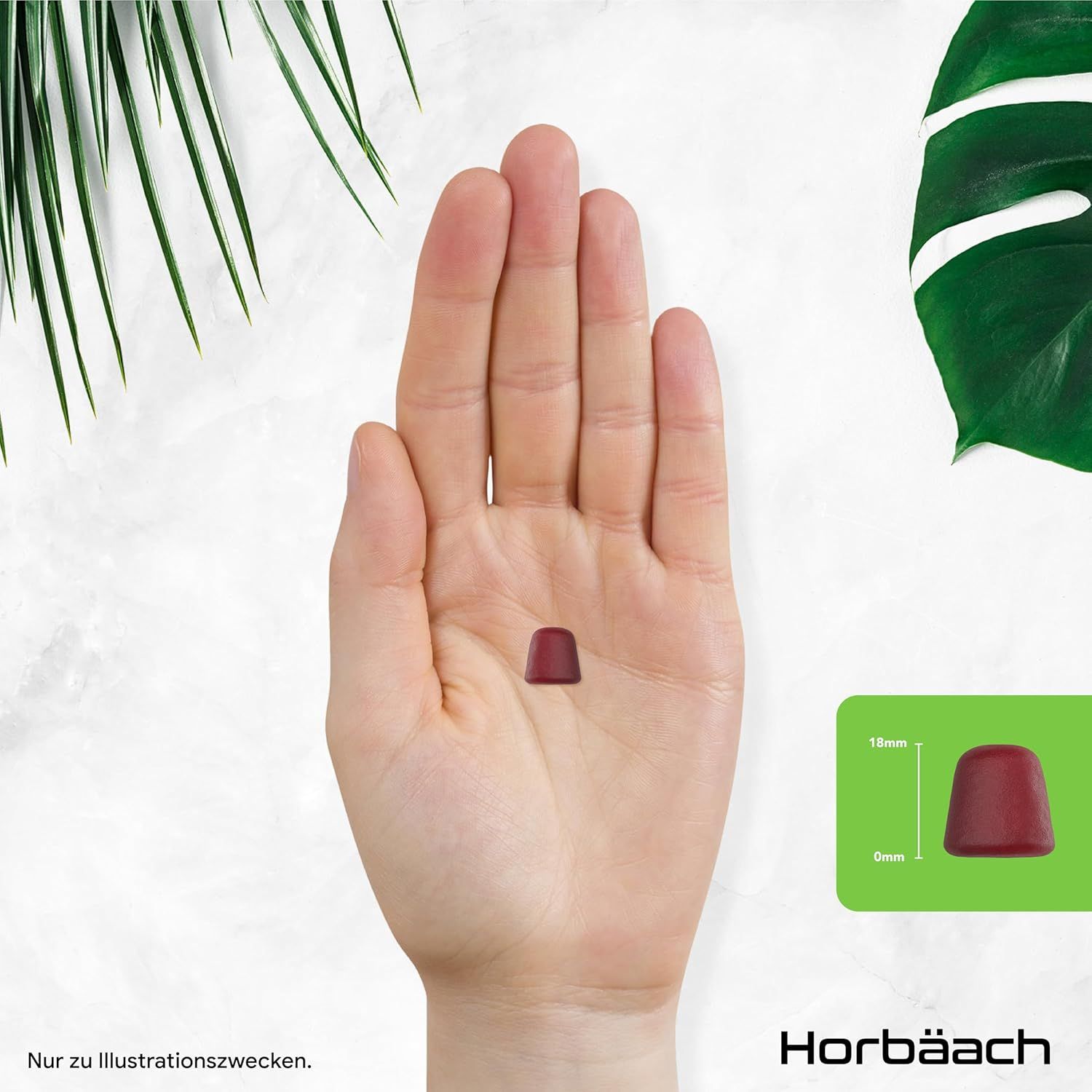 Mano con una caramella gommosa rossa. Dimensioni: 15mm x 9mm. Sfondo: foglia verde. Solo a scopo illustrativo.