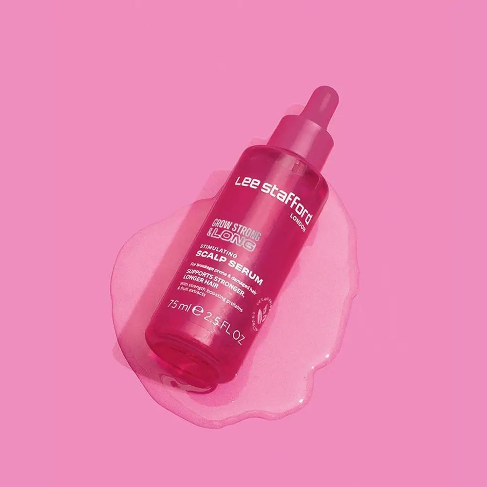 Flacone contagocce rosa del siero stimolante per cuoio capelluto Grow Strong & Long di Lee Stafford su sfondo rosa.
