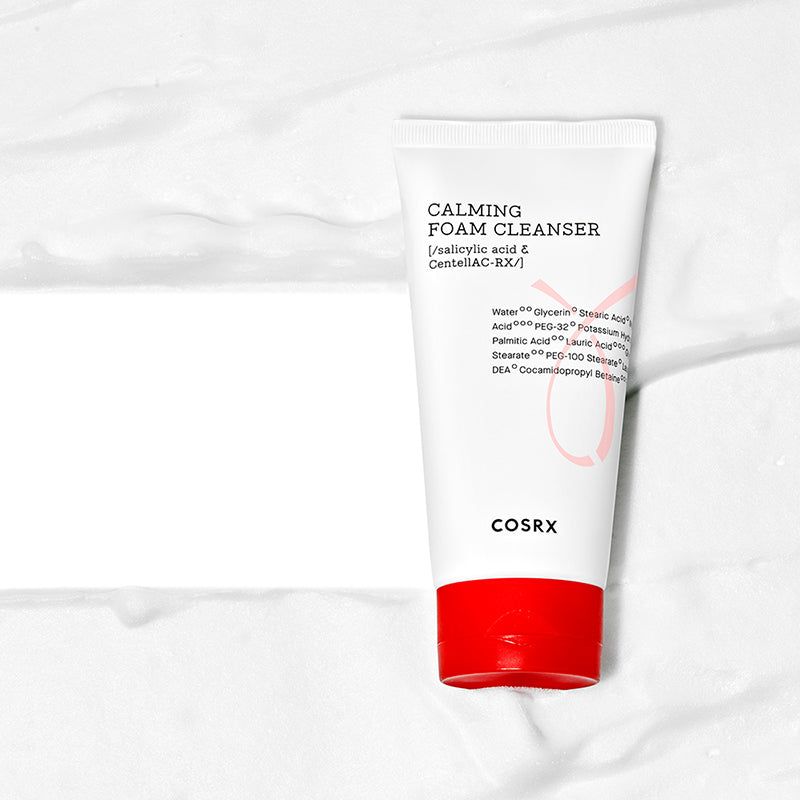Tubo bianco con tappo rosso nella schiuma. Scritta: Calming Foam Cleanser, ingredienti. Marchio: COSRX.