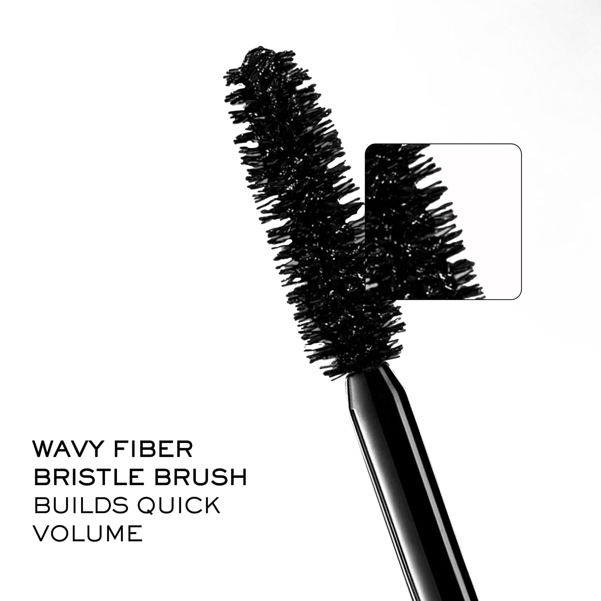 Primo piano di una spazzola per mascara. Testo: "WAVY FIBER BRISTLE BRUSH BUILDS QUICK VOLUME".