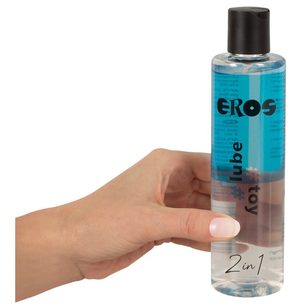 Flacone trasparente con tappo nero, tenuto da una mano. Liquido blu. Scritta: EROS, #toy lube, 2in1.