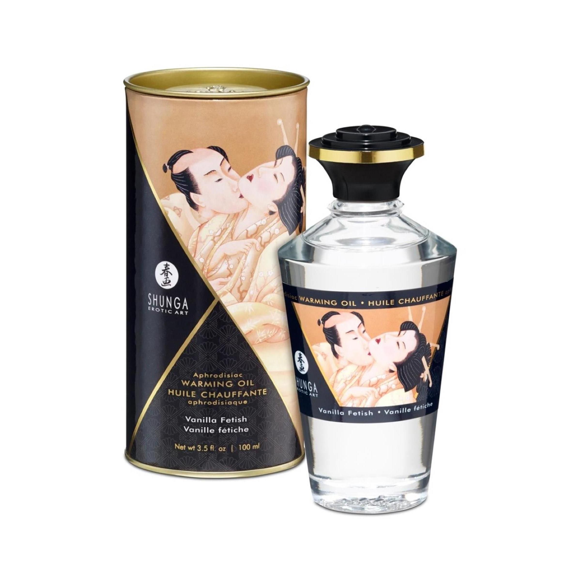 Confezione cilindrica e bottiglia. Testo: Shunga, Warming Oil, Vanilla Fetish. Coperchio dorato, sfondo nero.
