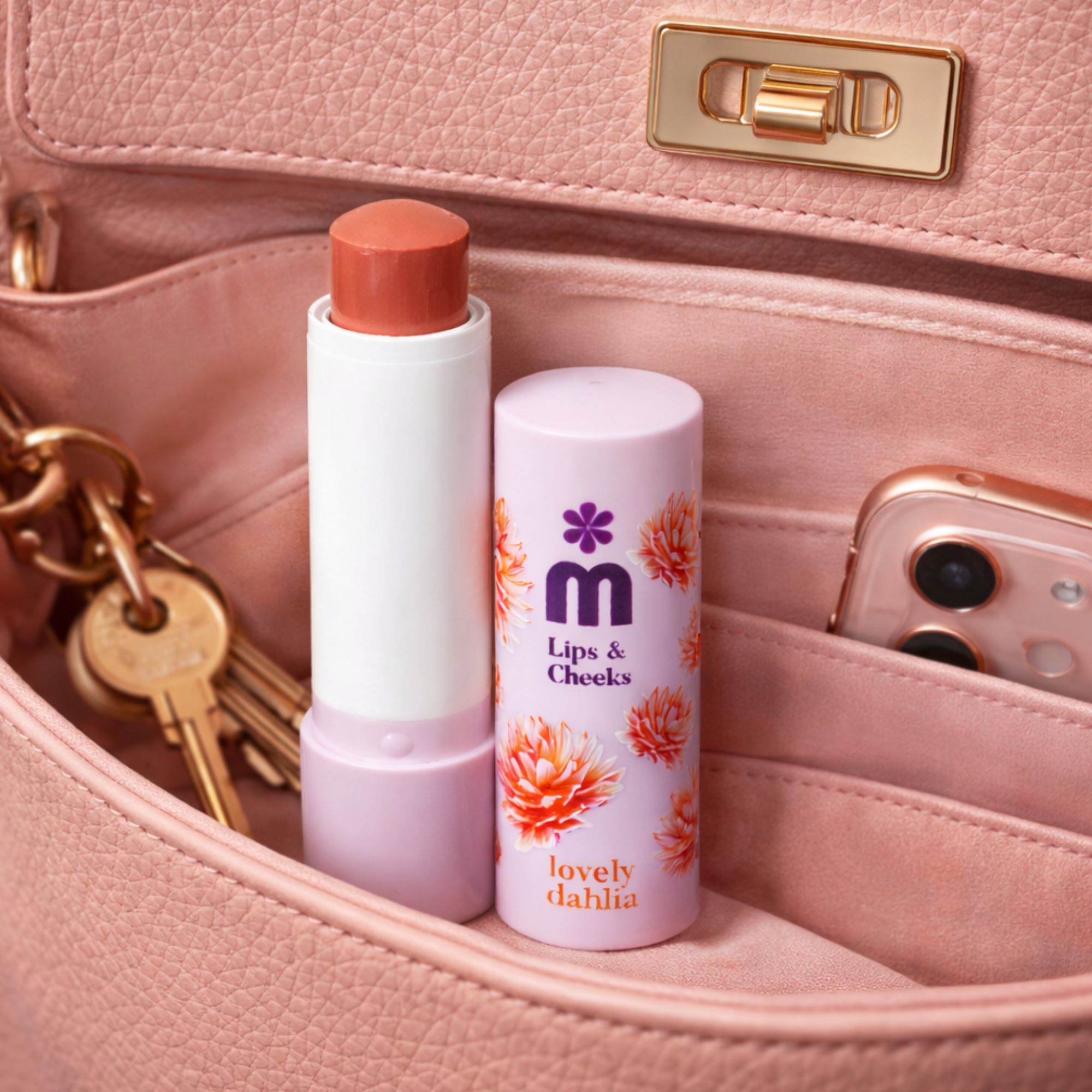 Balsamo per labbra e guance in una borsa. Stick bianco con balsamo rosa. Un telefono accanto.