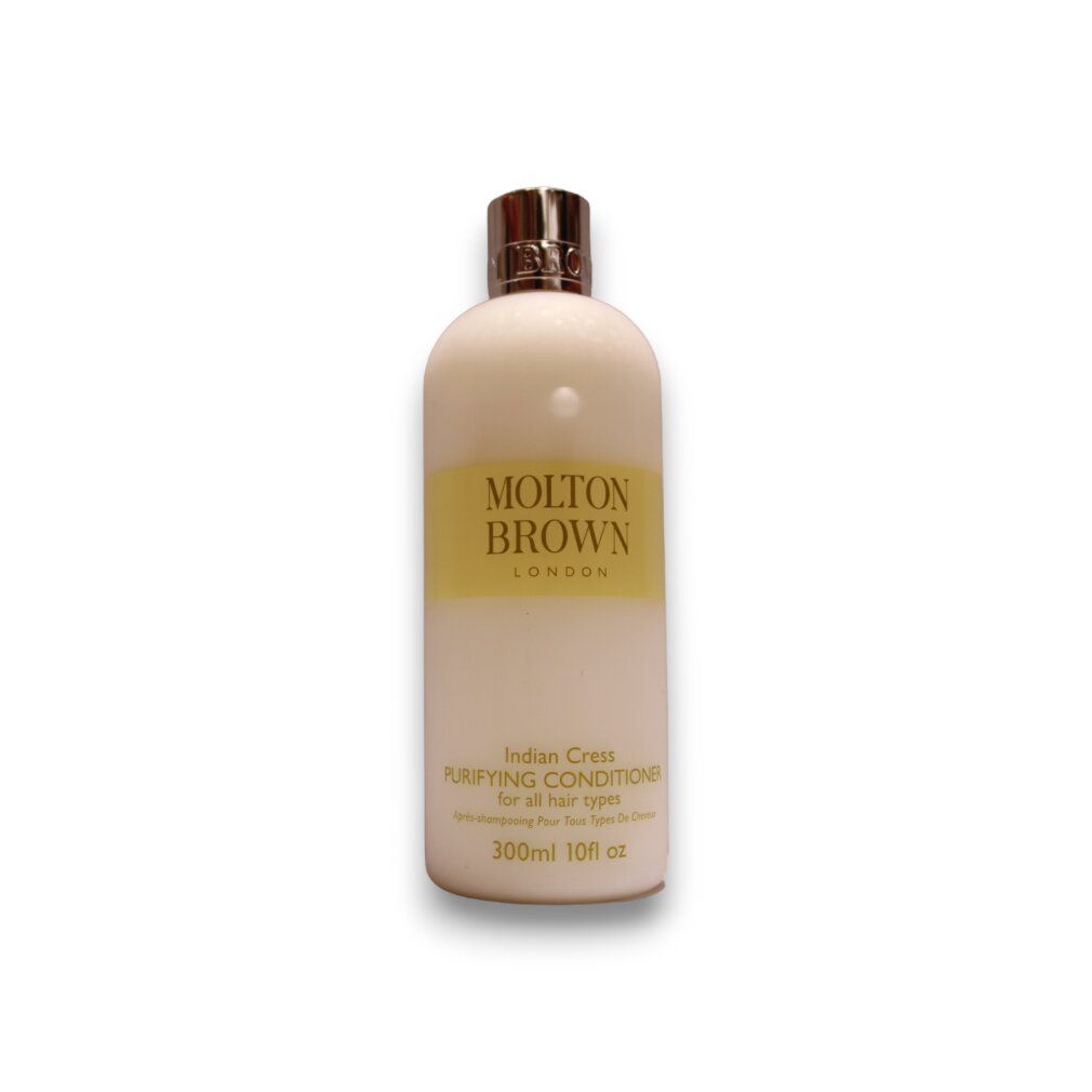 Flacone color crema con etichetta dorata e tappo argentato. Logo Molton Brown. Testo: Indian Cress Purifying Conditioner. 300ml 10fl oz.