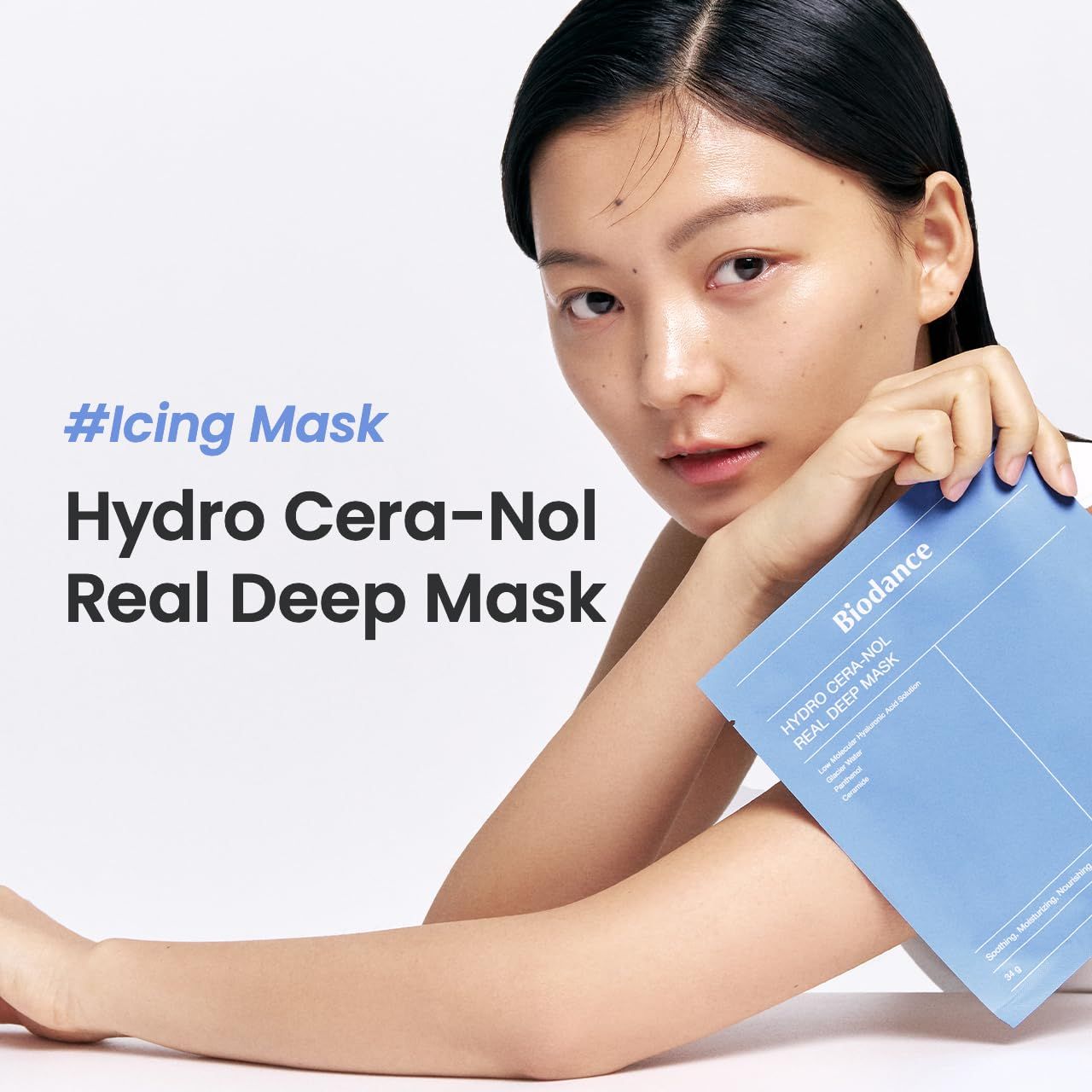 Donna che tiene in mano la confezione blu Biodance. Testo: #Icing Mask, Hydro Cera-Nol Real Deep Mask. Viso con pelle chiara. Sfondo bianco.
