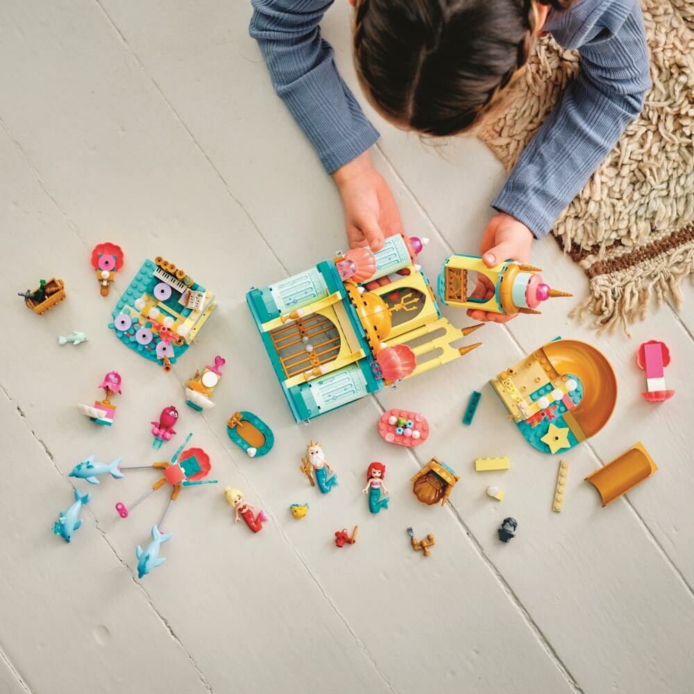 LEGO Disney Il Palazzo Sottomarino di Ariel. Il set è sparso sul pavimento, con personaggi, pezzi del castello e accessori. Una persona è visibile mentre gioca. Il set è adatto a bambini dai 6 anni in su.