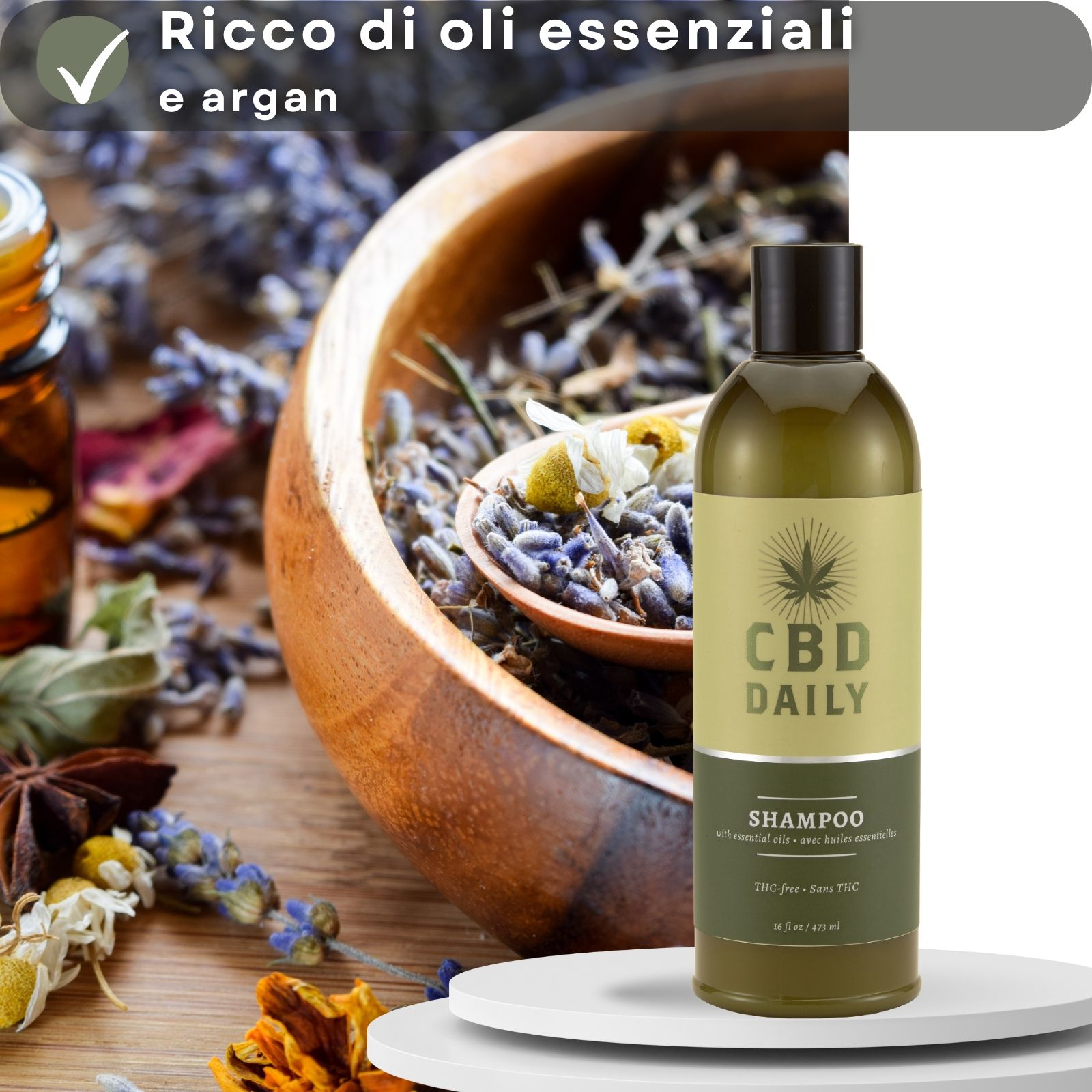 Flacone di shampoo CBD. Testo: CBD DAILY SHAMPOO. Sfondo: erbe e ciotola di legno. Testo: Oli essenziali e argan.