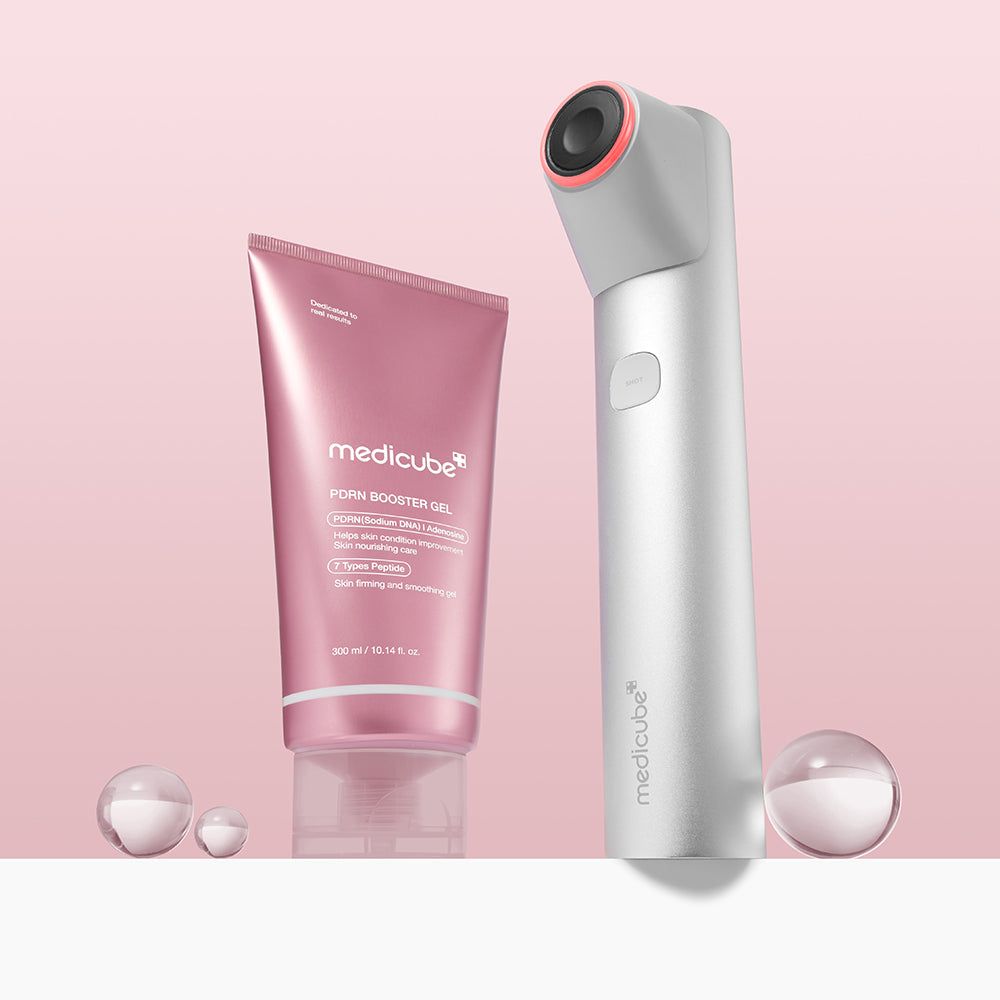 Tubo rosa MEDICUBE PDRN Booster Gel e un dispositivo bianco. Due sfere trasparenti in primo piano.