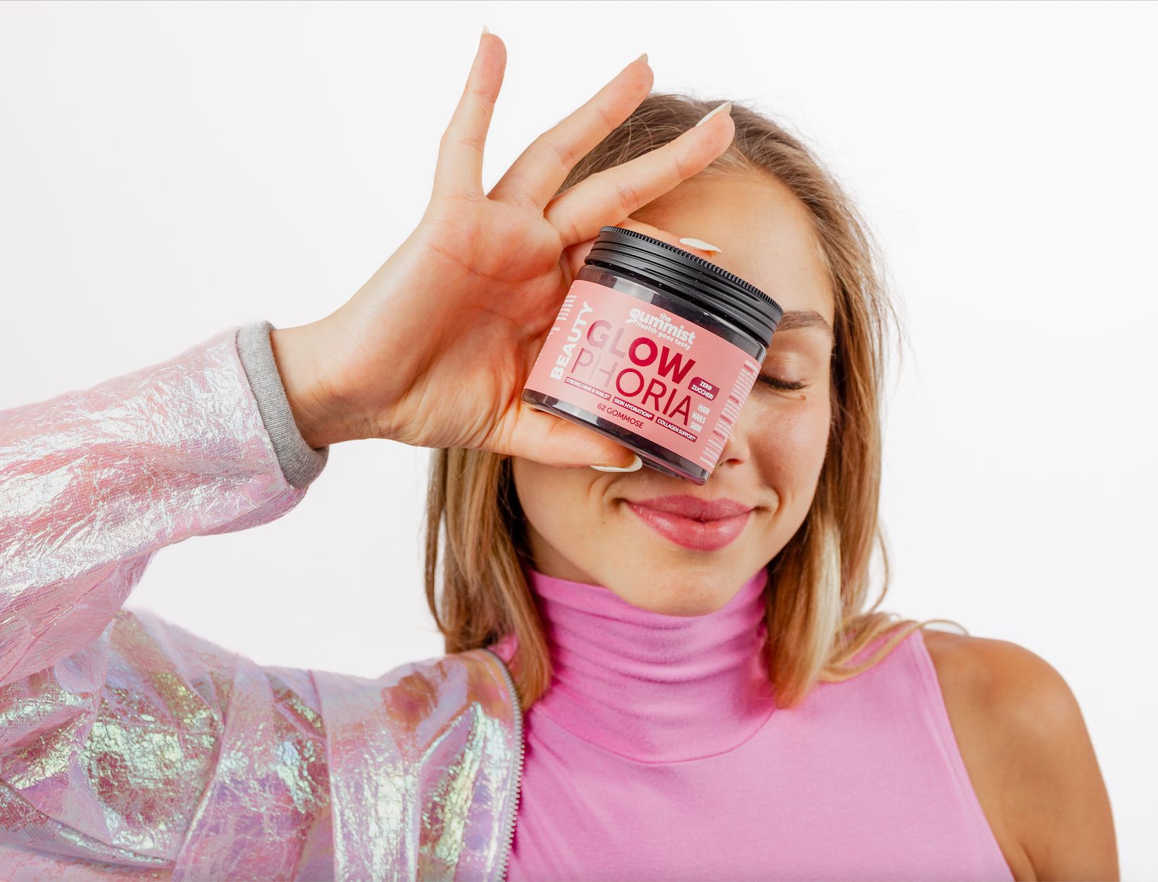 Donna tiene un barattolo di caramelle gommose davanti all'occhio. Scritta: Glowphoria.