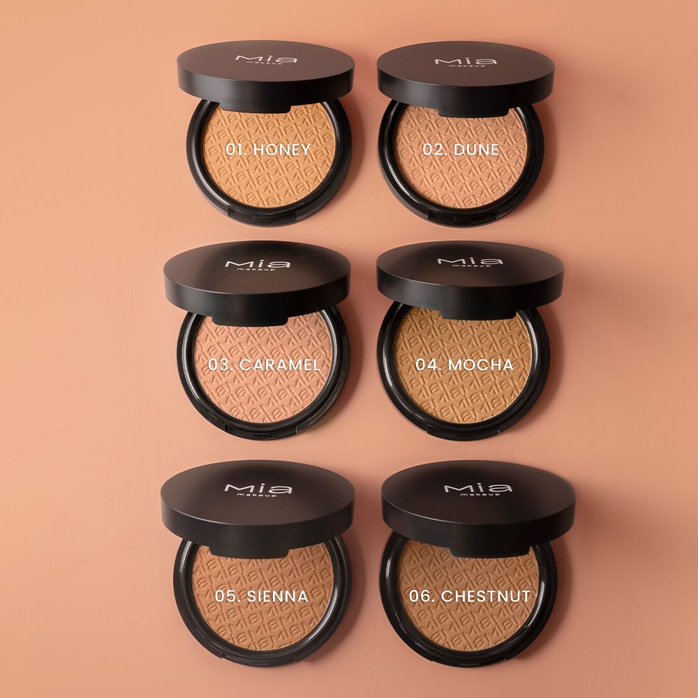 Sei contenitori cosmetici rotondi aperti con polvere marrone. Coperchi neri con logo Mia Makeup. Varianti colore: Honey, Dune, Caramel, Mocha, Sienna, Chestnut.