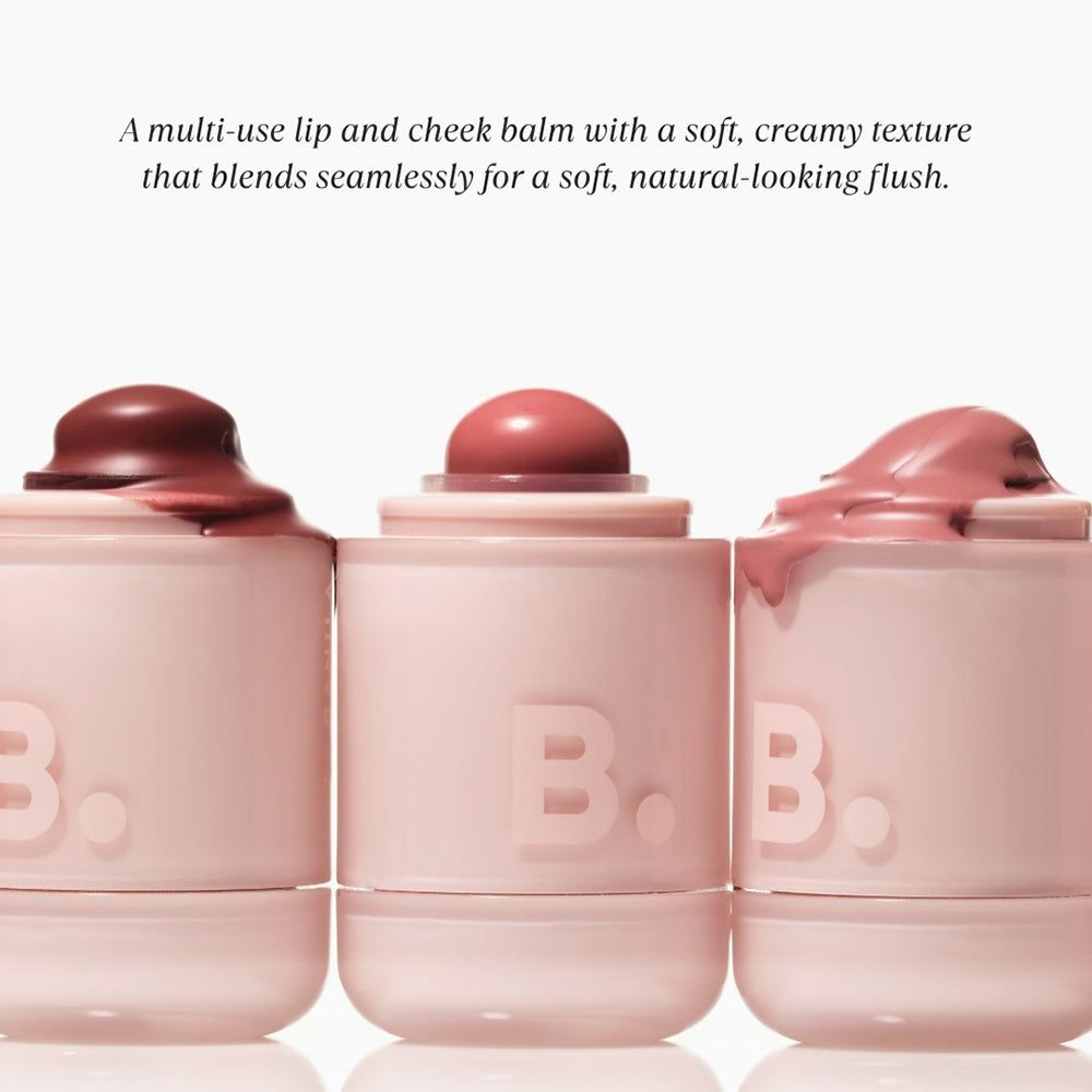 Tre balsami per labbra e guance rosa. I coperchi sono ricoperti di prodotto. Il logo "B." è visibile sui vasetti.
