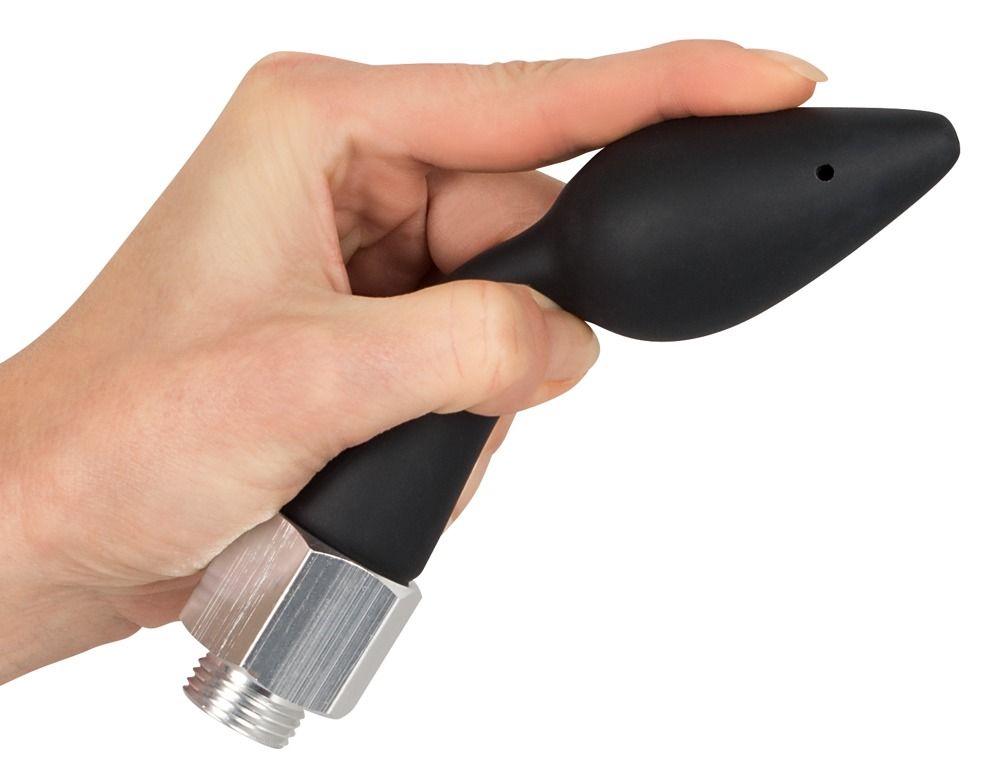 Mano che tiene un plug anale nero con raccordo filettato argentato.