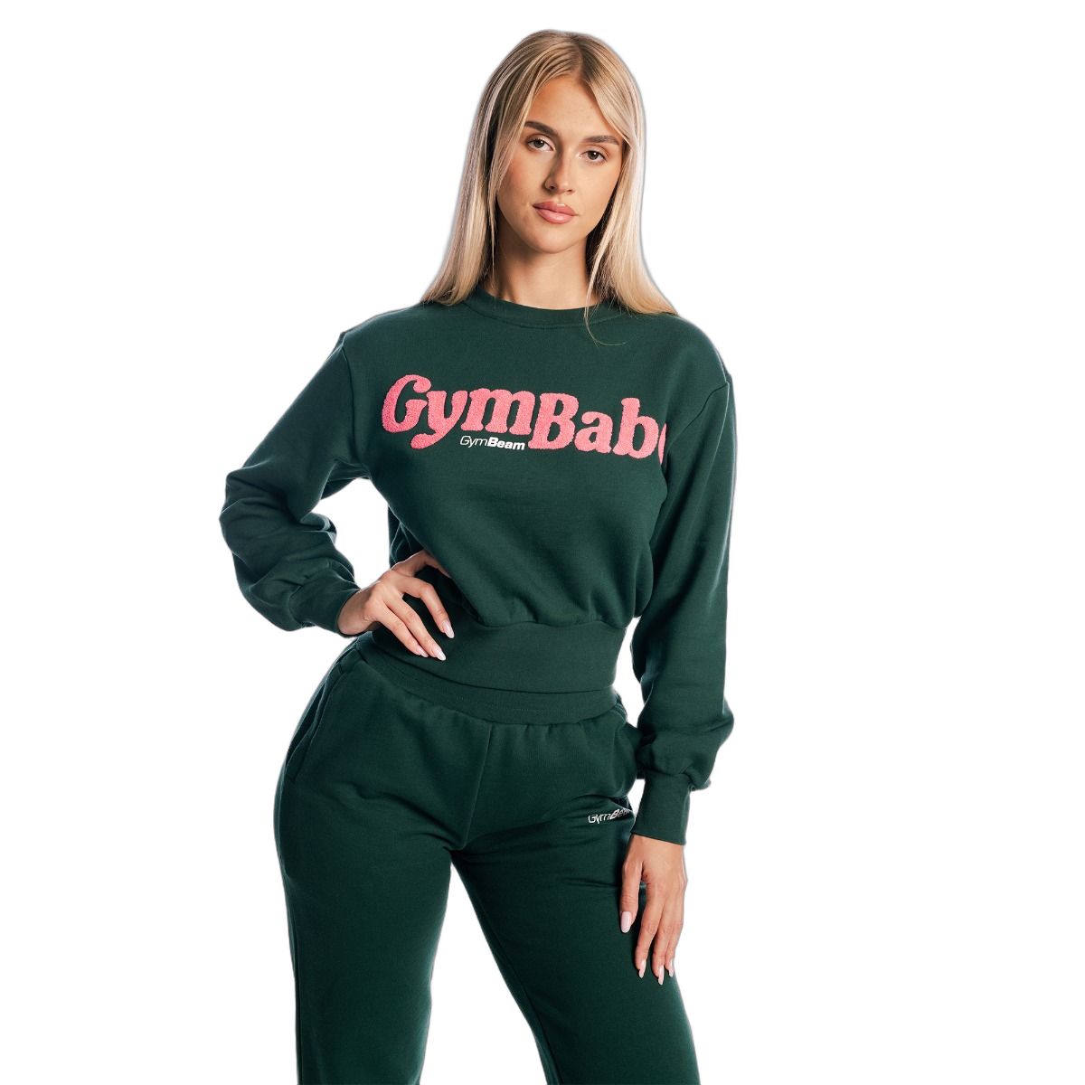 Donna con maglione cropped da donna verde a maniche lunghe Forest e pantaloni della tuta. Scritta rosa 'GymBaby'.
