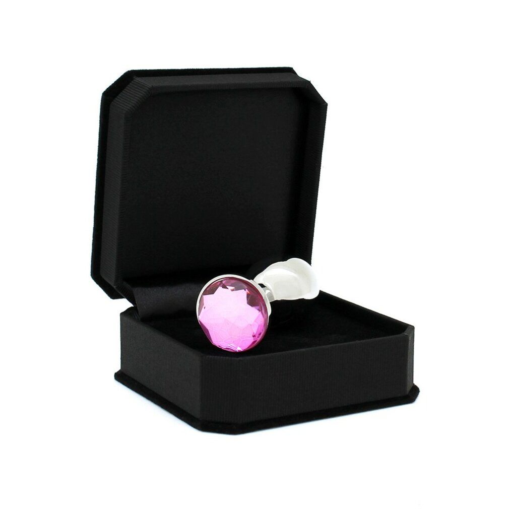 Plug anale con cristallo rosa in cofanetto nero. Lo stelo è bianco e il cristallo è rotondo.
