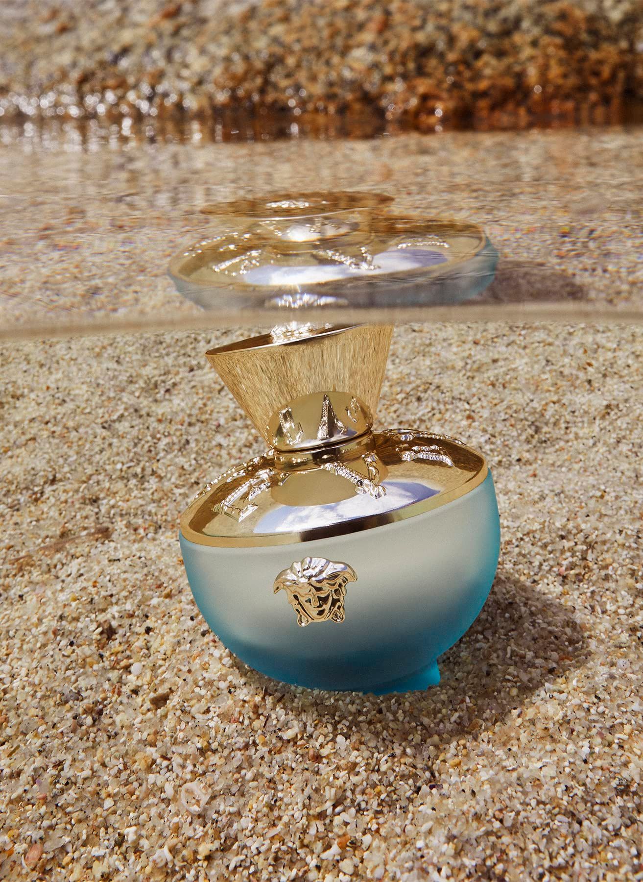 Flacone Versace Dylan Turquoise Eau de Toilette nella sabbia e nell'acqua.