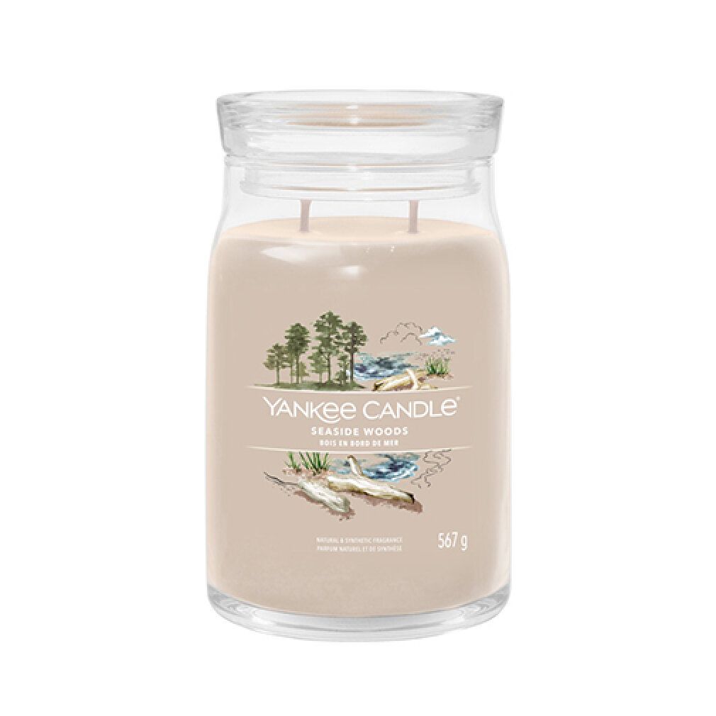Contenitore di vetro con coperchio. Scritta: Yankee Candle Seaside Woods. 567 g. Illustrazione di spiaggia e alberi.