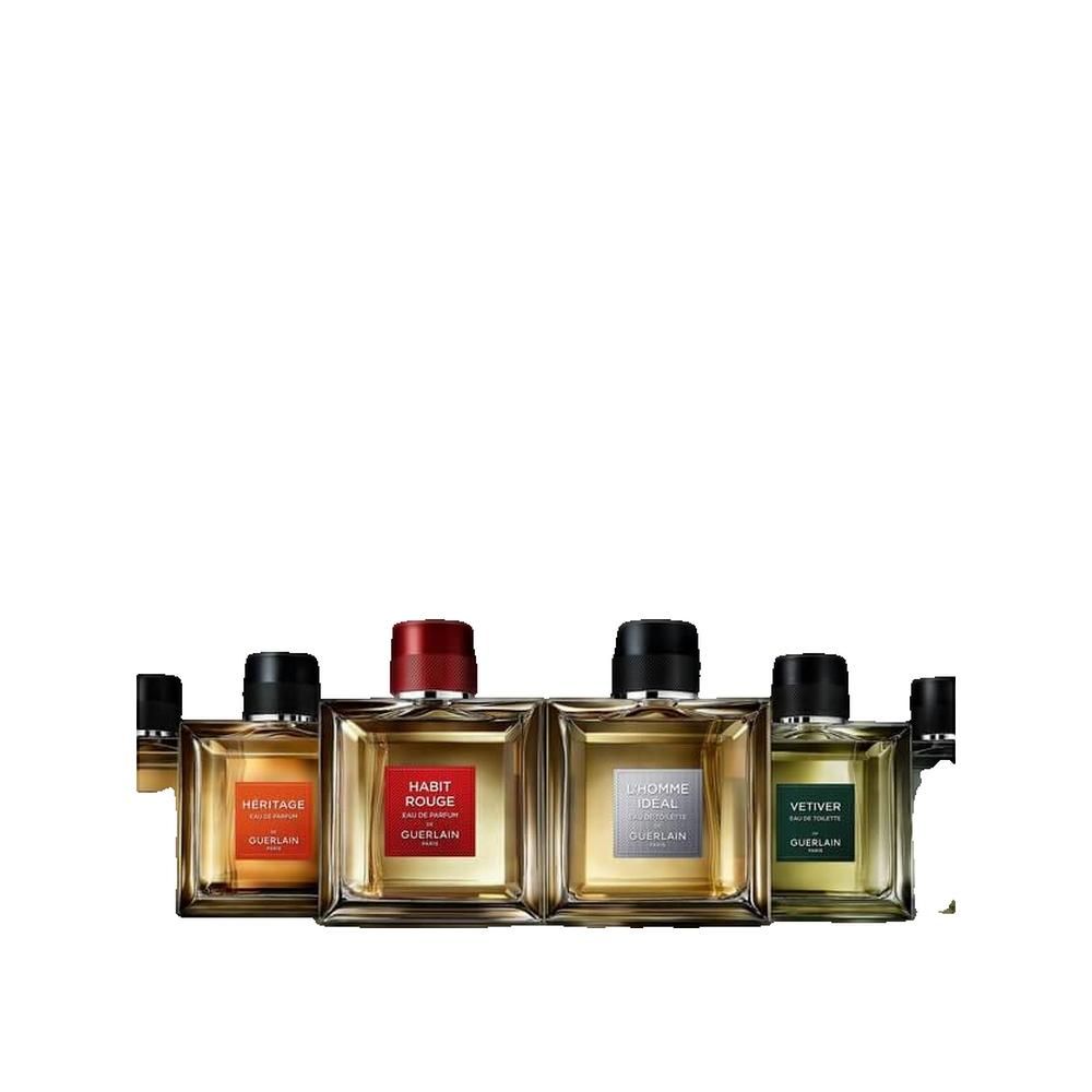 Quattro flaconi affiancati. Héritage, Habit Rouge, L'Homme Idéal, Vétiver. Tutti quadrati, con tappo nero o rosso.