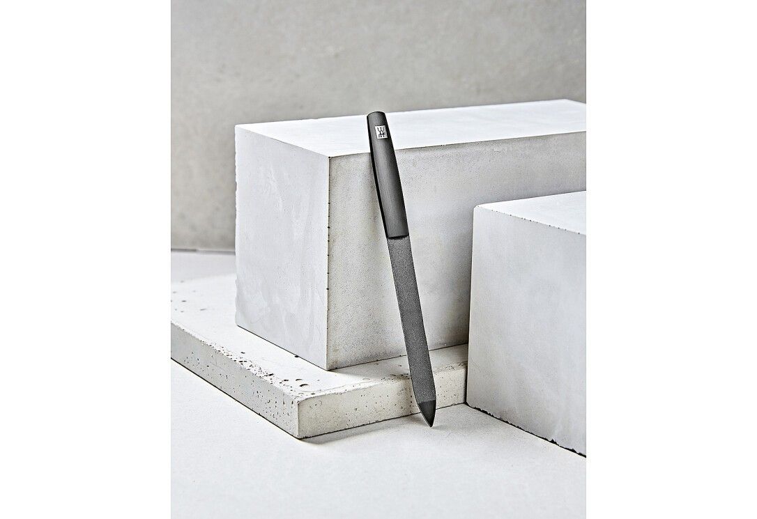 Lima per unghie a forma di penna grigio scuro con punta affilata e finitura opaca.