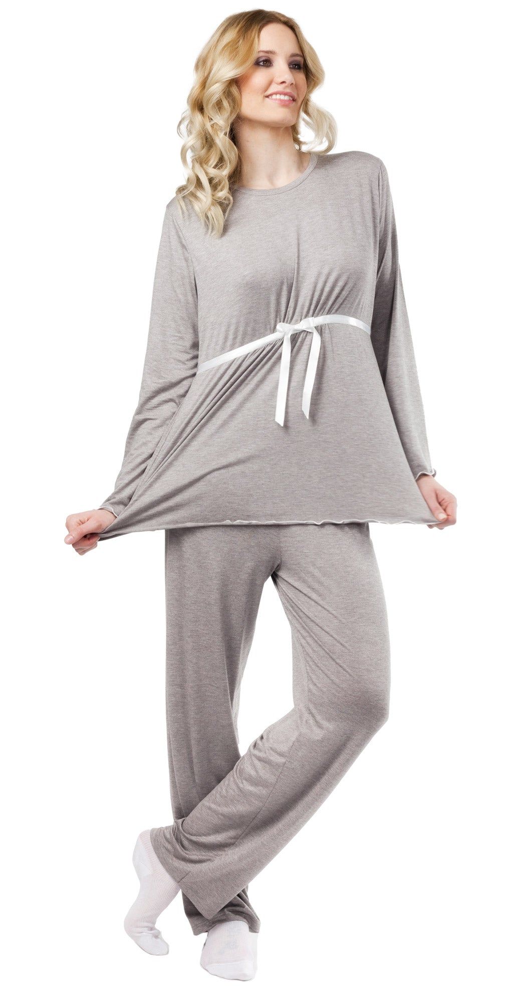 Pigiama premaman grigio. Top a maniche lunghe con nastro bianco. Pantaloni a gamba dritta. Donna che indossa il pigiama.