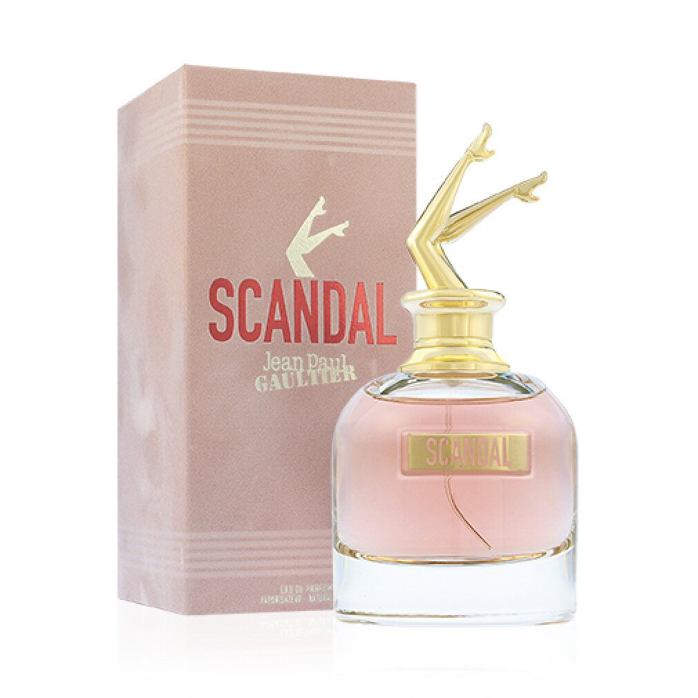 Flacone di profumo con tappo a forma di gambe dorate e confezione rosa. Scritta "SCANDAL" e "Jean Paul Gaultier".