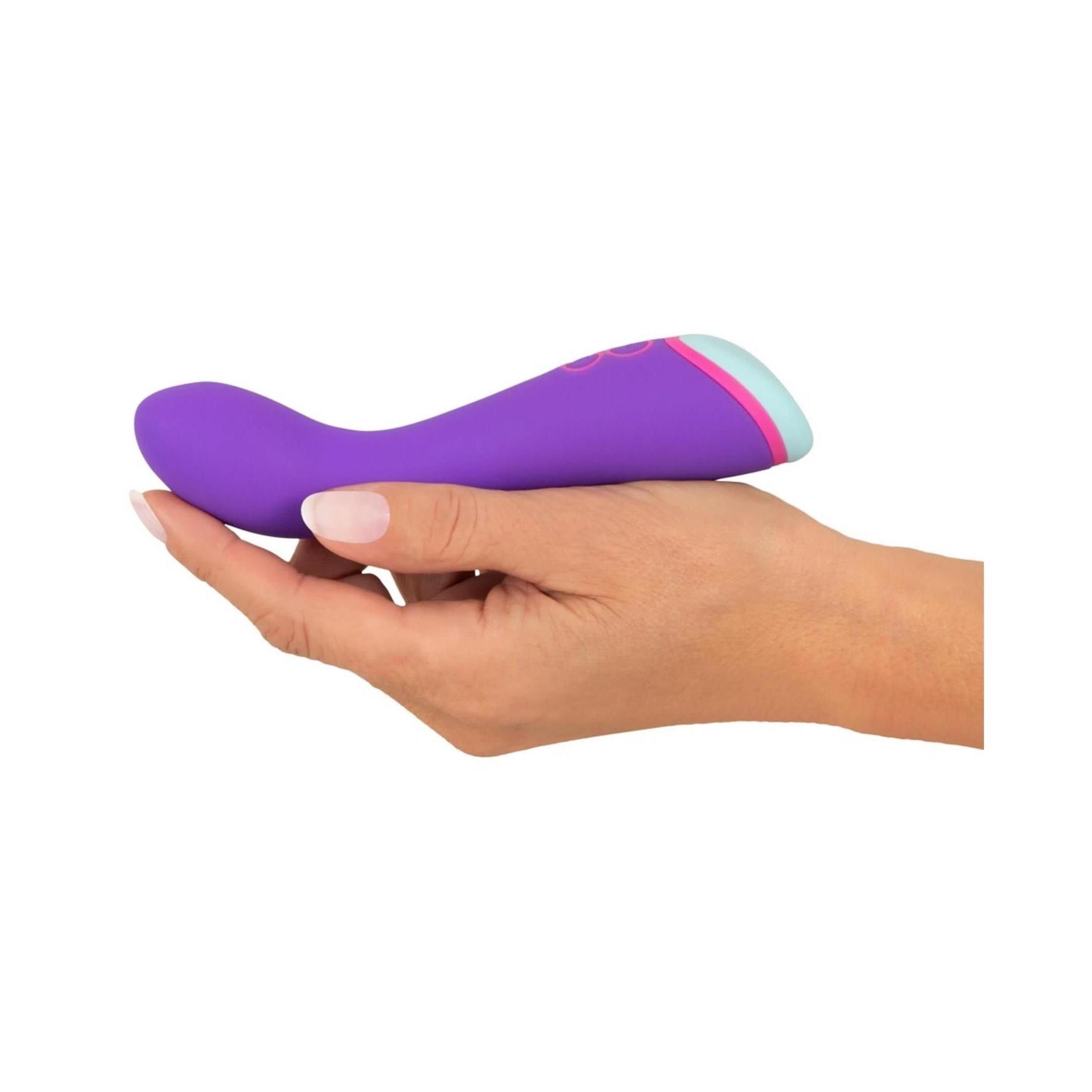 Vibratore viola tenuto in una mano. Accenti rosa e azzurro chiaro all'estremità.