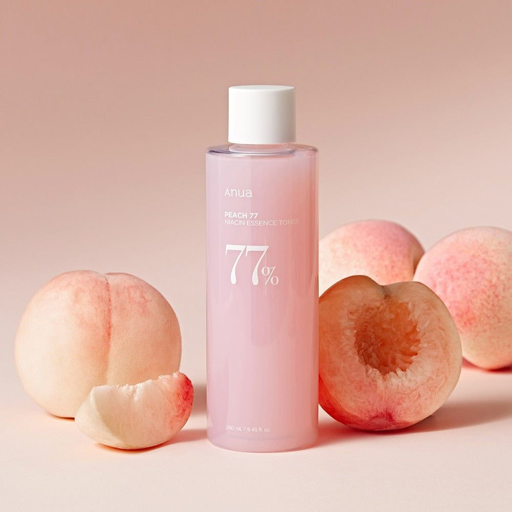 Flacone rosa con tappo bianco e pesche. Scritta: Peach 77 Niacin Essence Toner. 77% in bianco.