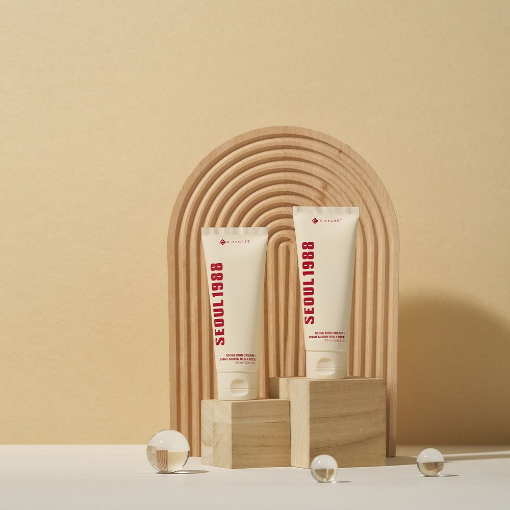 Due tubi di SEOUL 1988 Cream su piedistalli di legno e pietra.