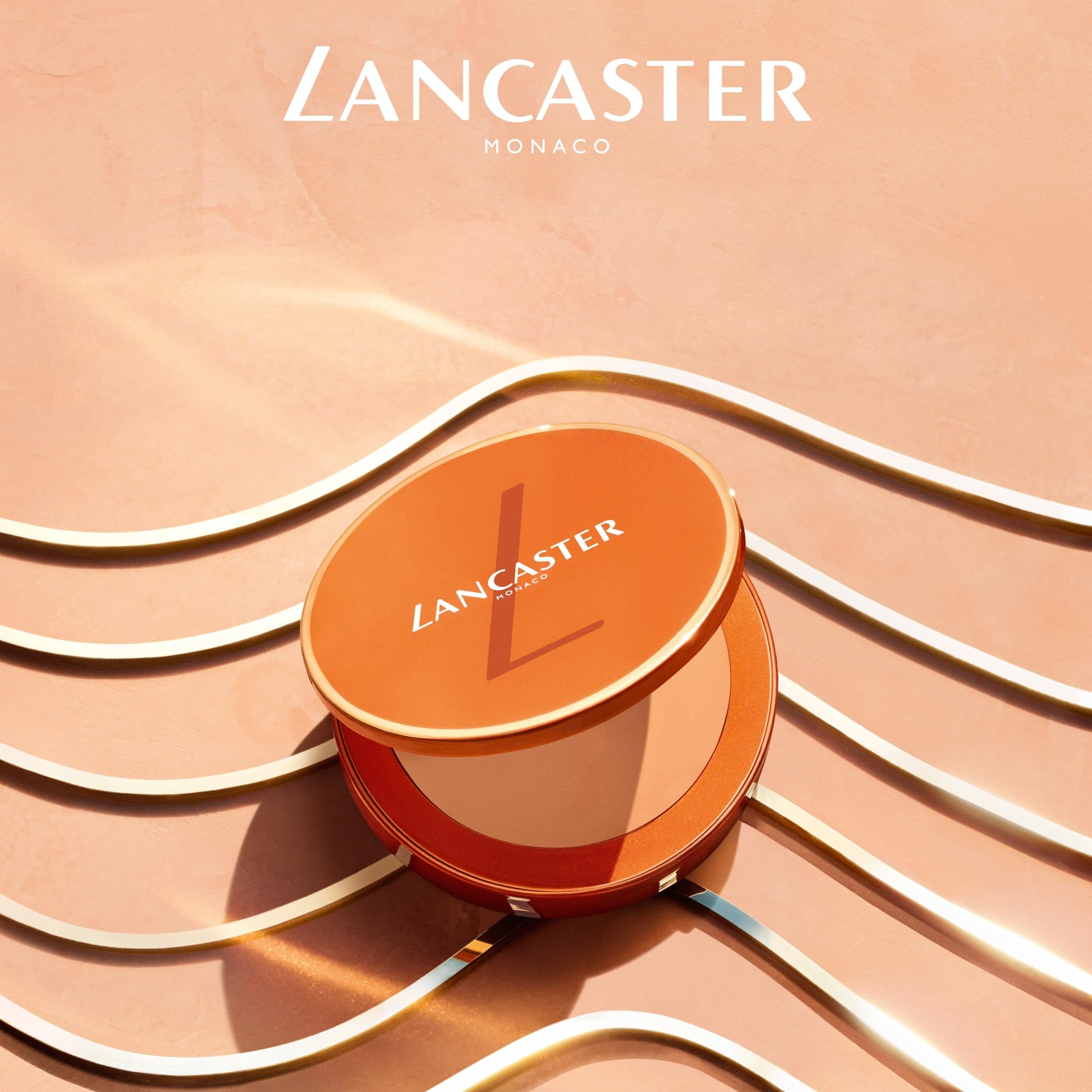 Crema solare compatta arancione aperta. Coperchio con logo LANCASTER. Interno: crema colorata. Sfondo: linee dorate.