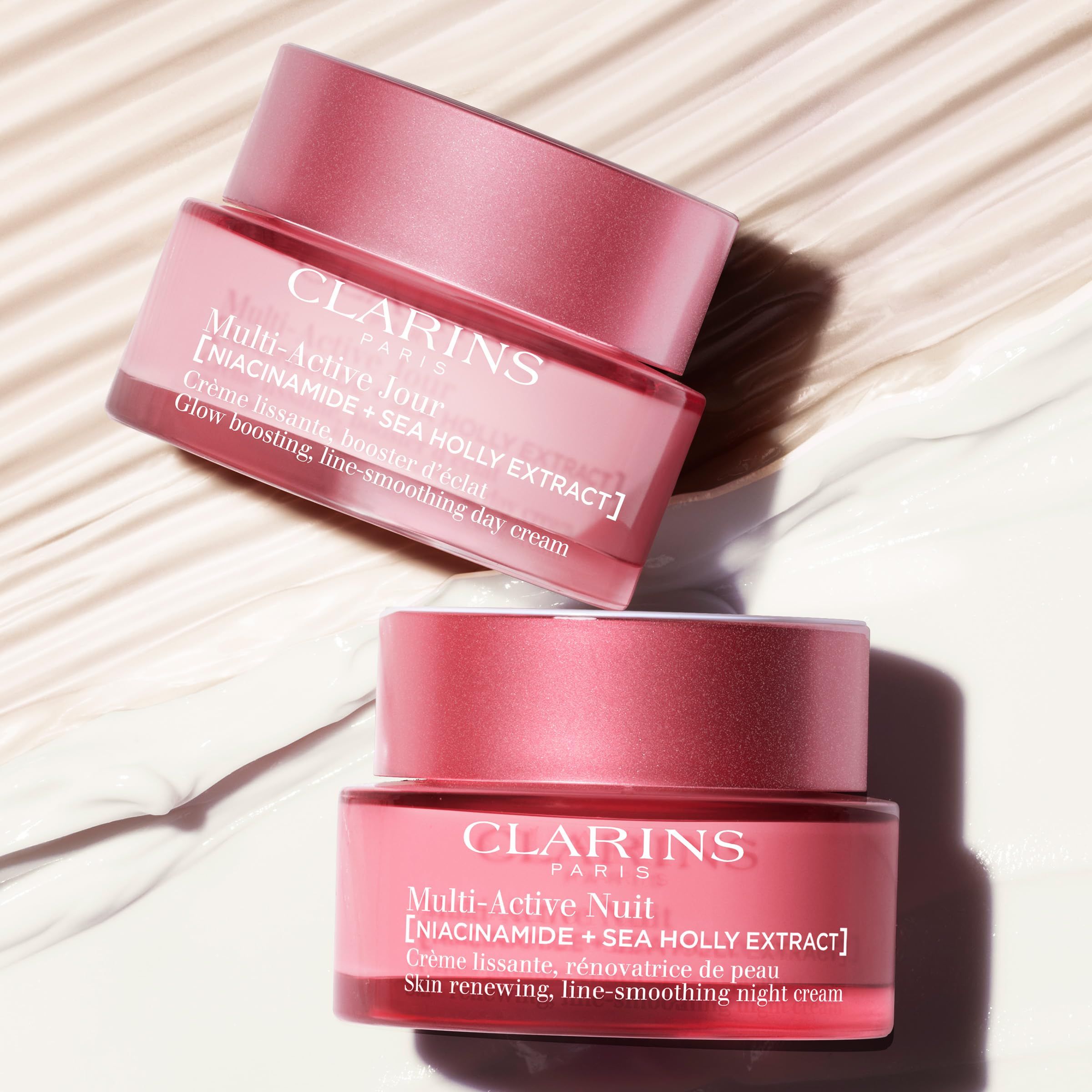 Due vasetti rosa. Scritta: CLARINS PARIS, Multi-Active Jour e Nuit, [NIACINAMIDE + SEA HOLLY EXTRACT].
