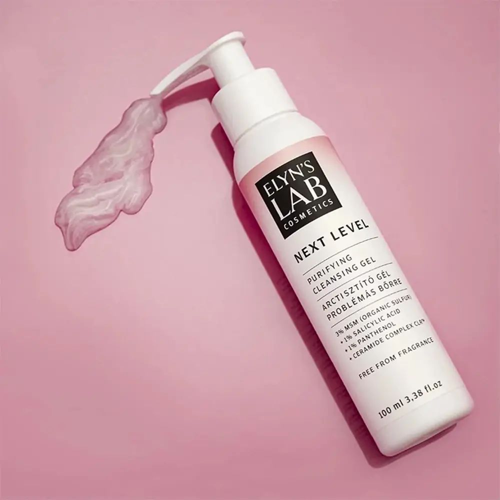 Flacone bianco con dosatore, etichetta rosa. Testo: ELYN'S LAB, NEXT LEVEL, gel detergente. Gel rosa erogato.
