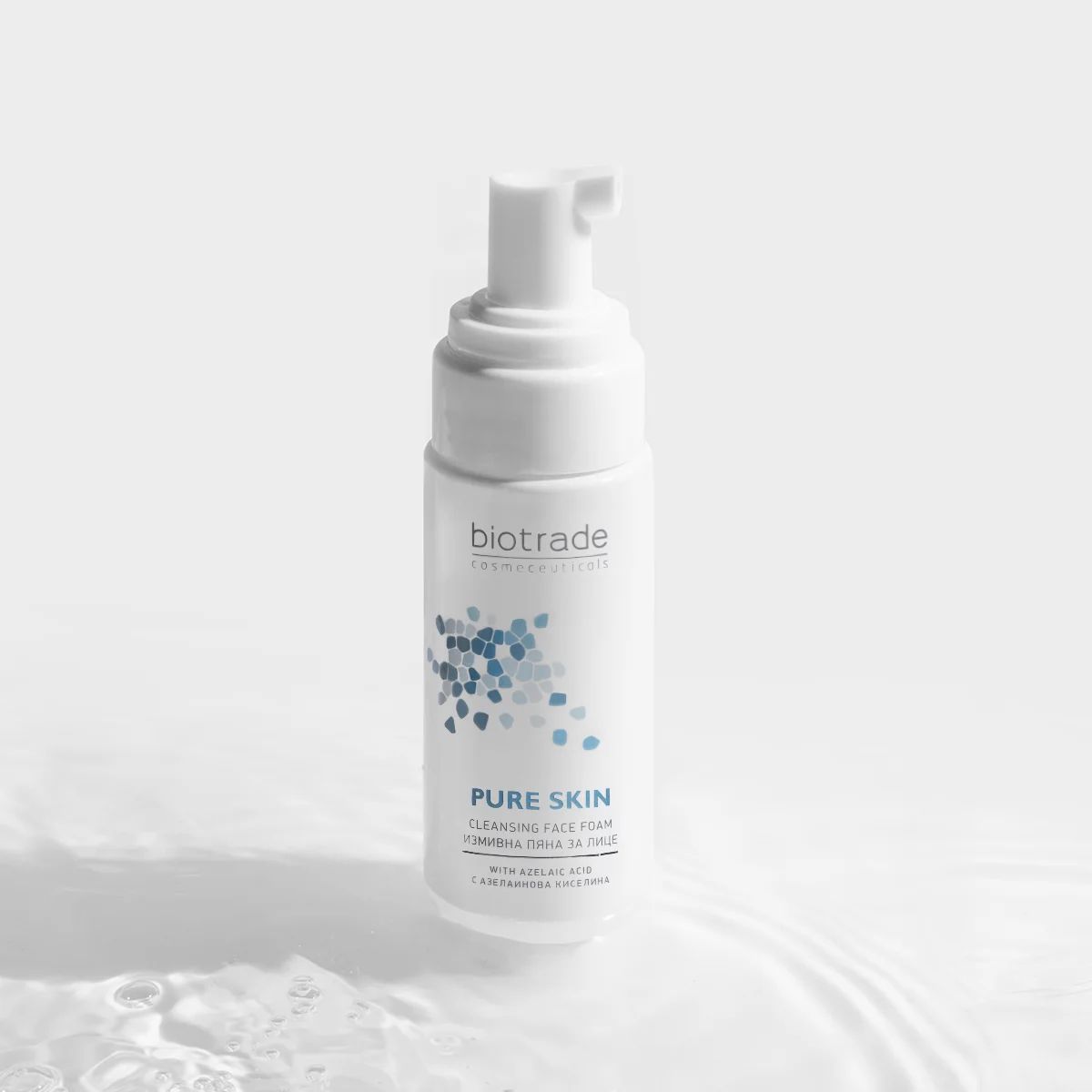 Flacone bianco con dosatore a pompa. Scritta: Biotrade, Pure Skin, schiuma detergente. Elementi grafici blu.