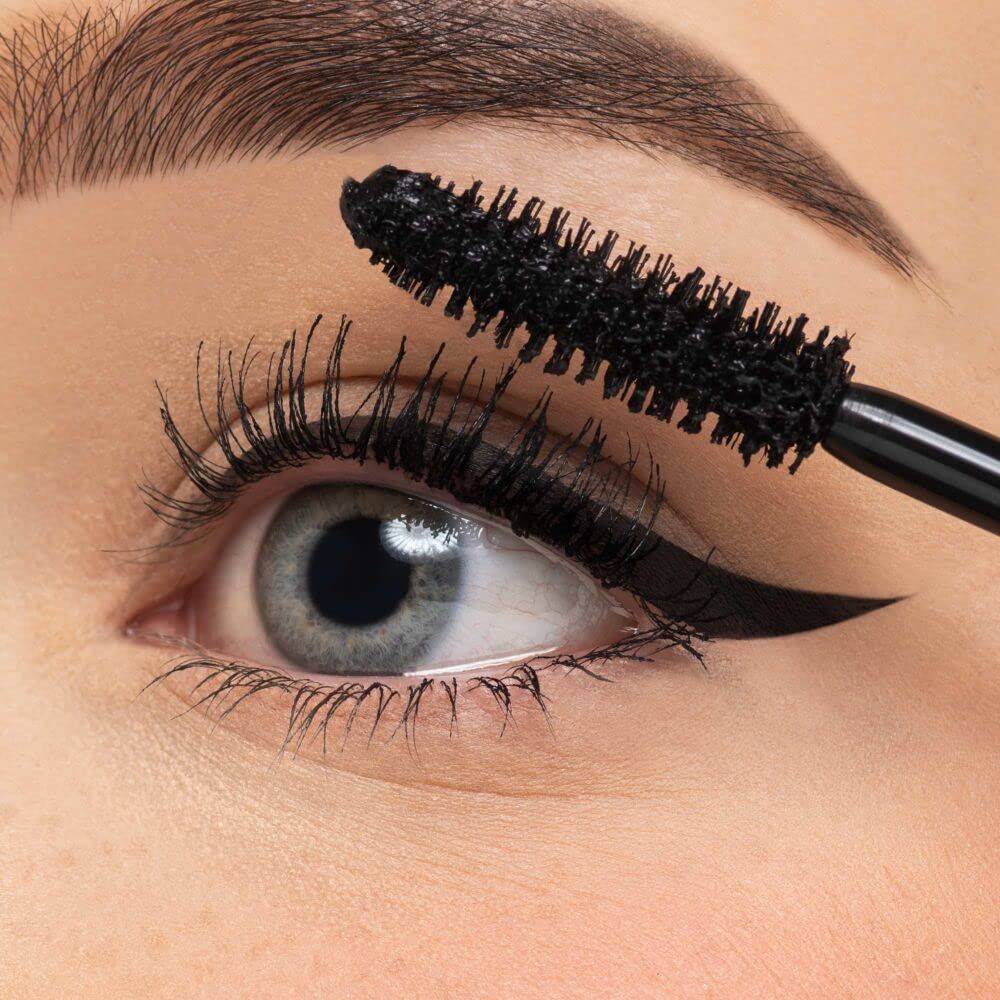 Occhio con applicatore di mascara. Mascara nero sulle ciglia. Tratto di eyeliner.