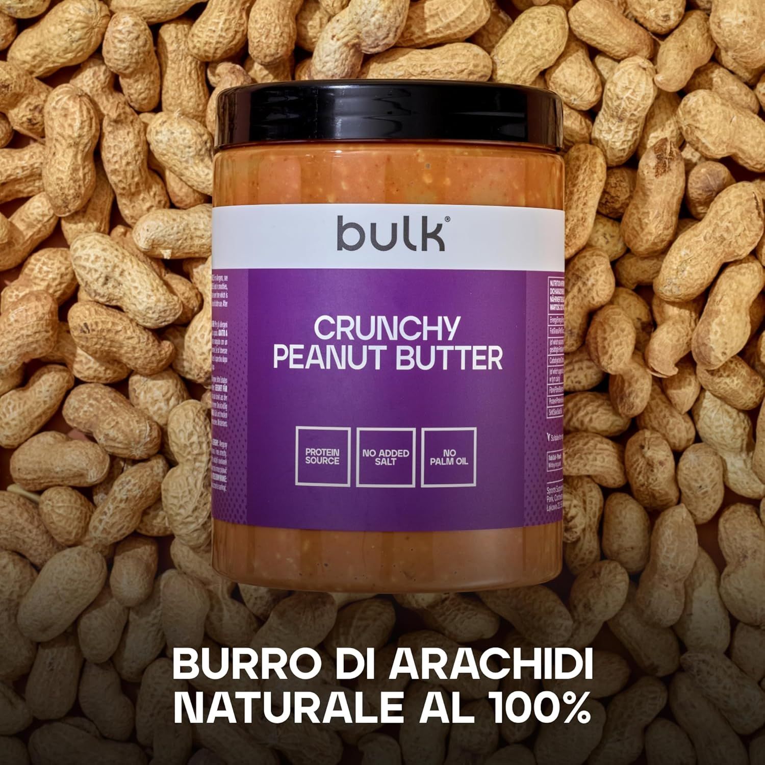 Vasetto di burro di arachidi su arachidi. Etichetta viola con "bulk", "Crunchy Peanut Butter", "Protein Source", "No Added Salt", "No Palm Oil".