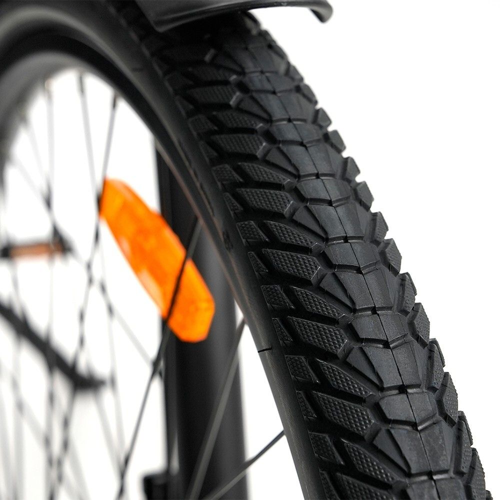 Primo piano di uno pneumatico nero con battistrada. Un catarifrangente arancione è visibile.