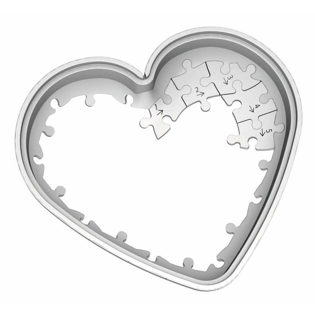 Cornice per puzzle a forma di cuore. Alcuni pezzi del puzzle sono inseriti. Plastica grigia. Frecce che indicano l'ordine dei pezzi.