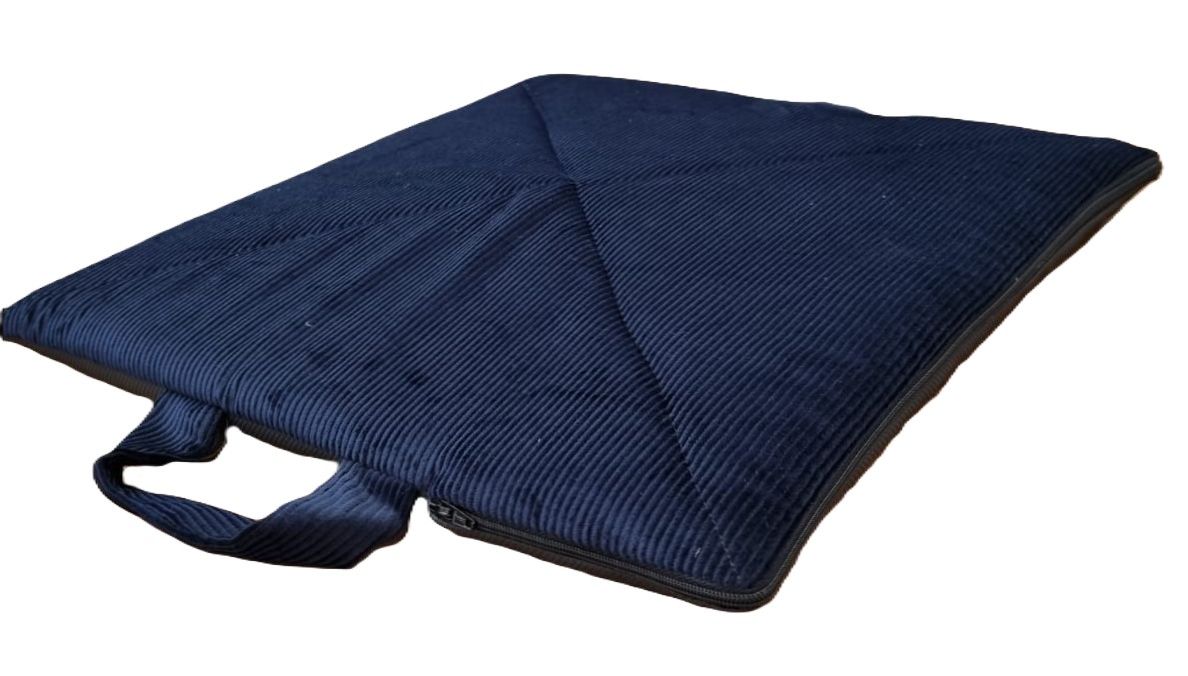 Cuscino quadrato blu con maniglia e cerniera. Superficie trapuntata. Aspetto a coste.