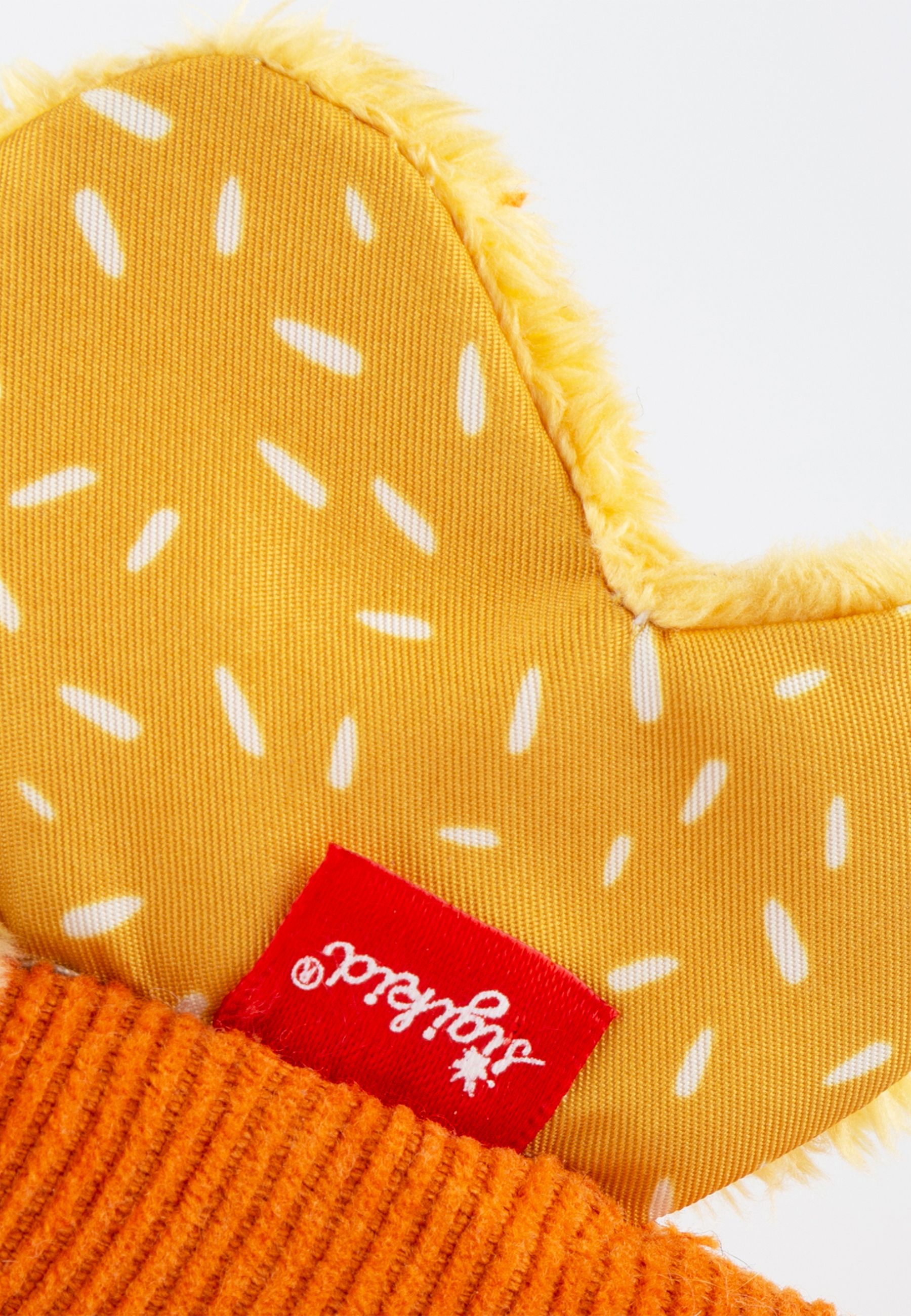 Primo piano di una parte della farfalla. Ala gialla con punti bianchi. Etichetta rossa "sigikid". Corpo arancione.